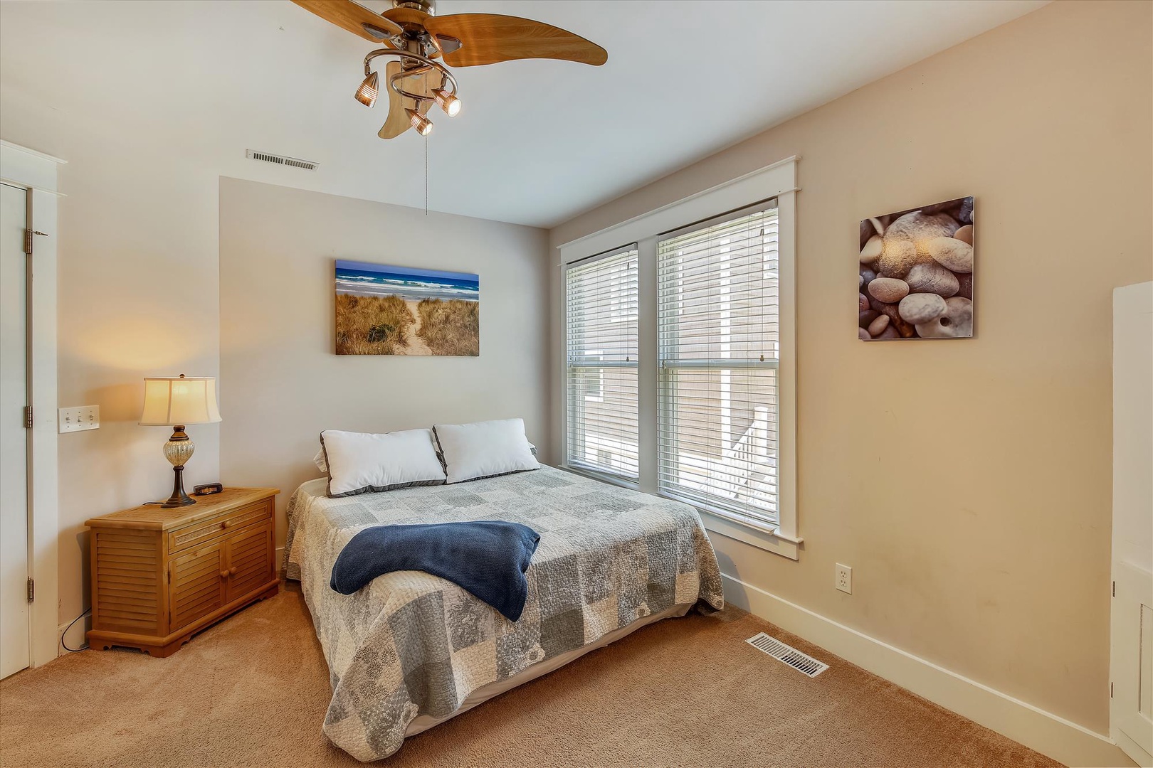 Drift off in this peaceful bedroom with coastal artwork and a gentle ceiling fan keeping you comfortable throughout your stay.