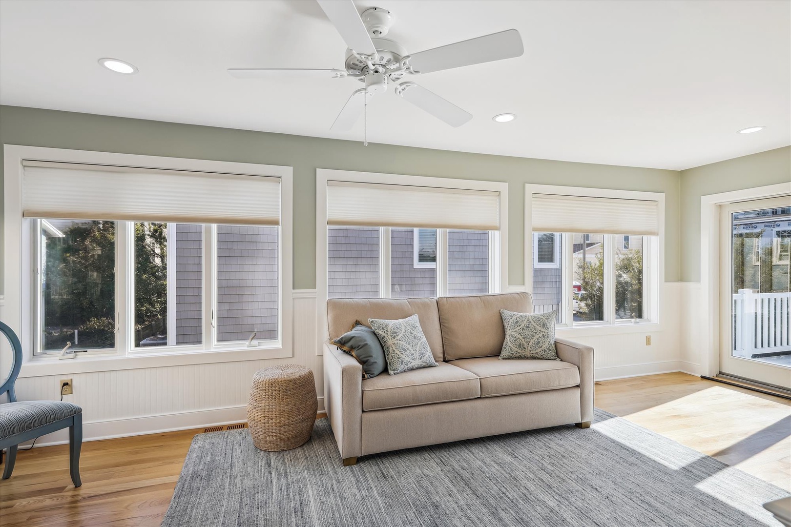 Sink into the cozy sofa and let natural light wash over you. This bright living space invites you to relax with soft coastal vibes and peaceful views.