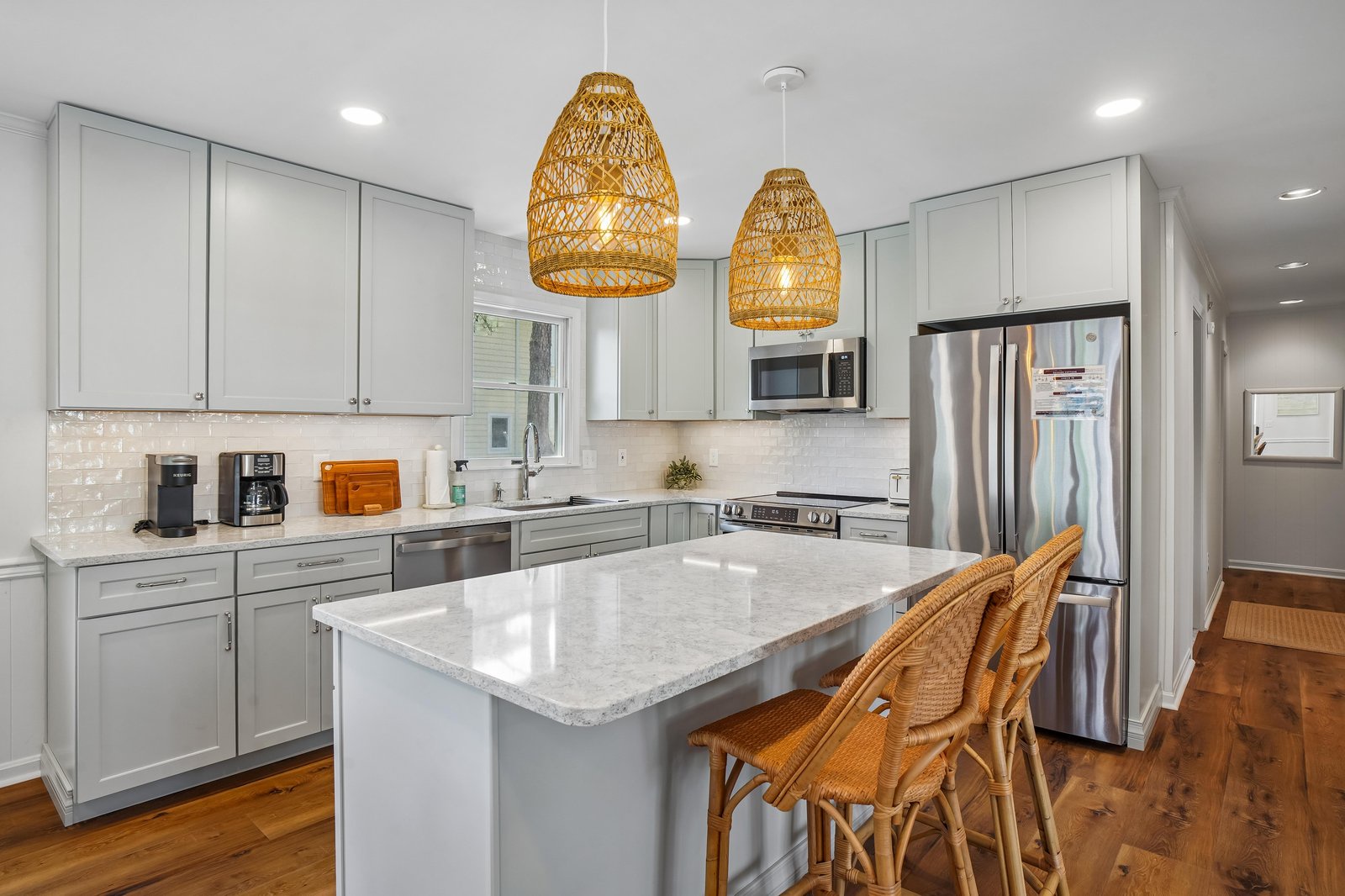 Your fully-equipped kitchen invites culinary creativity with its bright, airy design. Stainless steel appliances and a spacious island with seating make meal prep a breeze while warm pendant lights and natural touches create a welcoming, homey vibe.