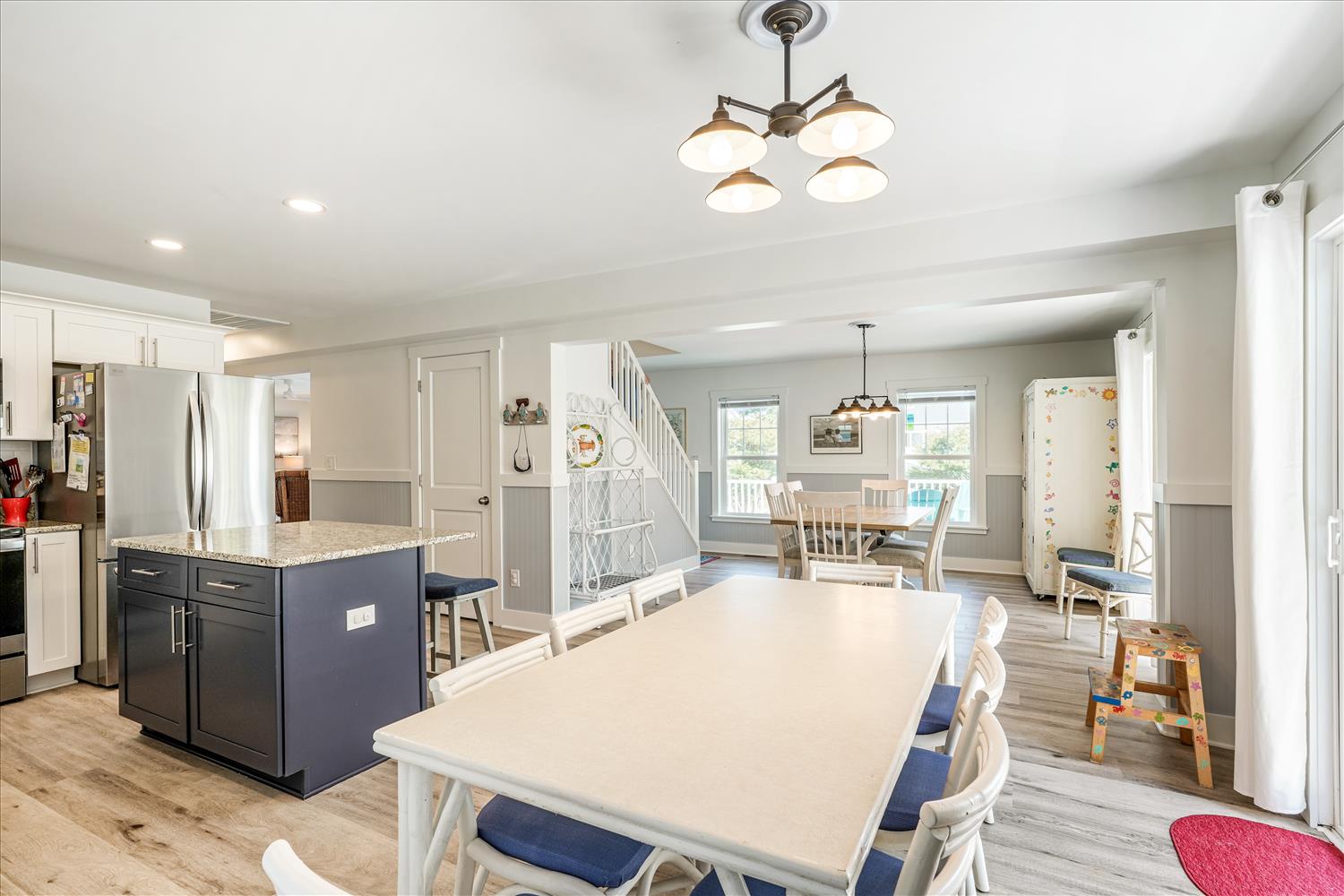 Gather around the spacious dining table where your group can share meals and make memories together. The open-concept design flows seamlessly into the modern kitchen, perfect for cooking and entertaining.