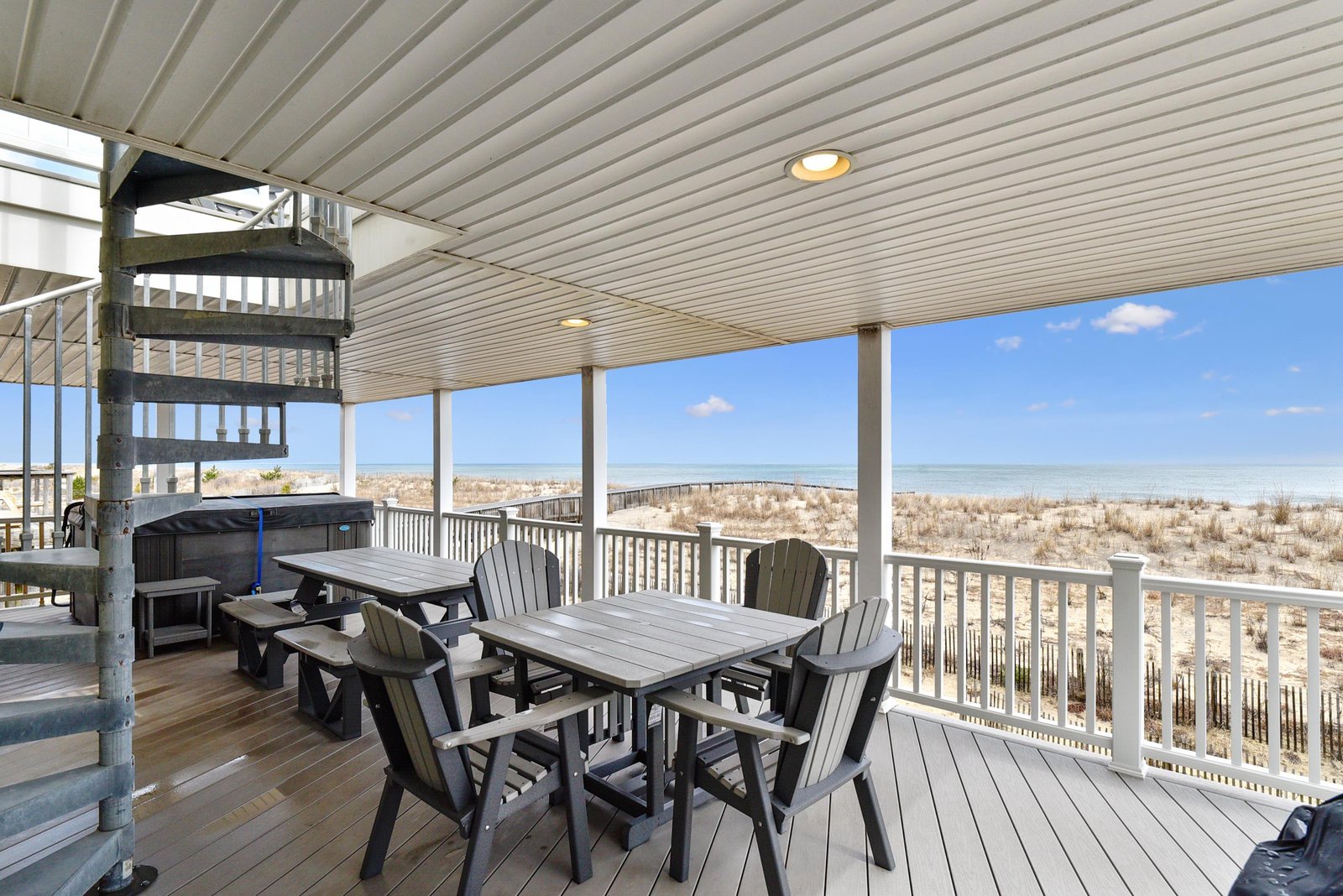 Relax on your private oceanfront deck with a hot tub and dining area, where soft sand and turquoise waters stretch endlessly before you.