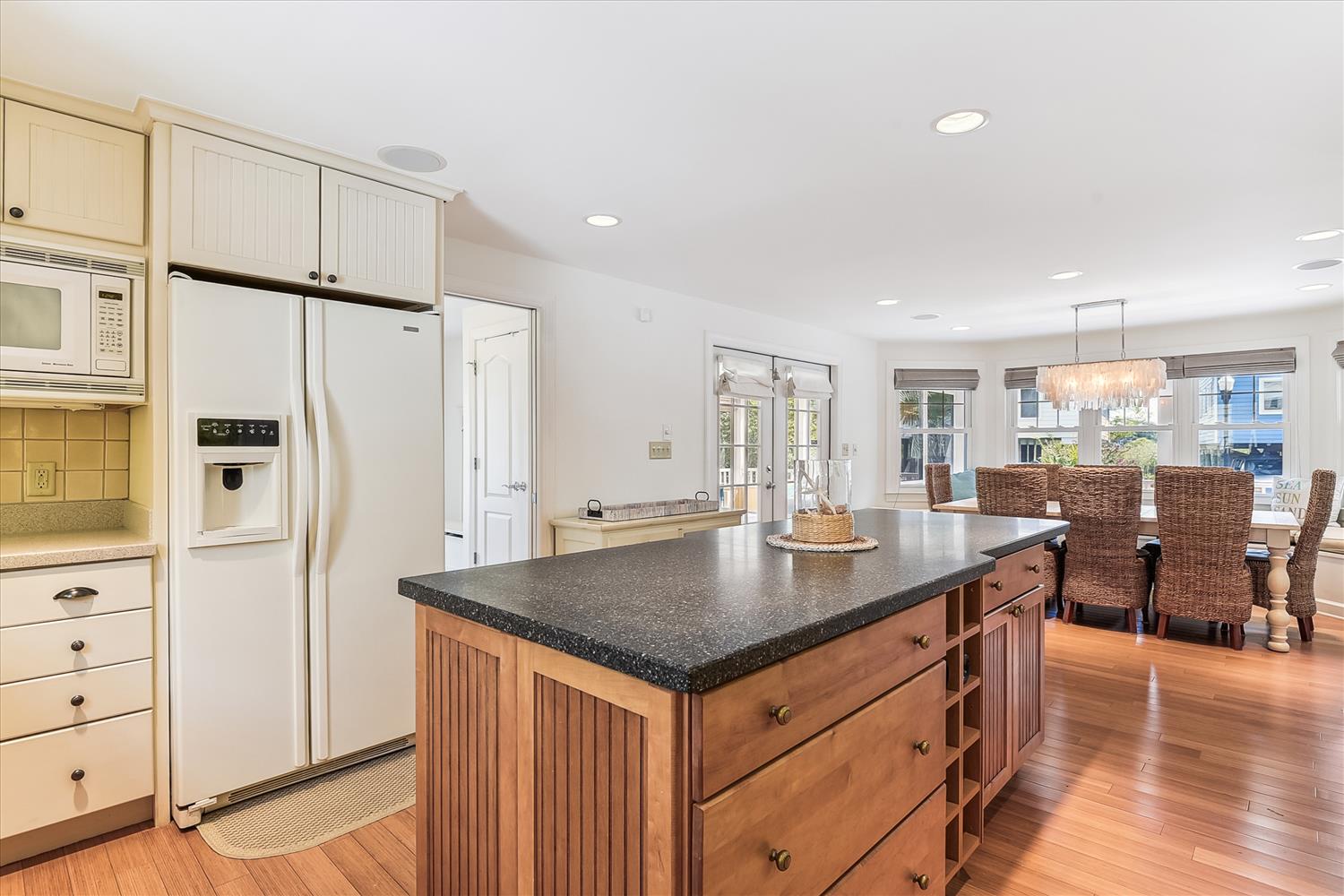 Gather around the spacious kitchen island with gleaming granite countertops. Natural light pours through windows, and the open layout flows seamlessly into the dining area.
