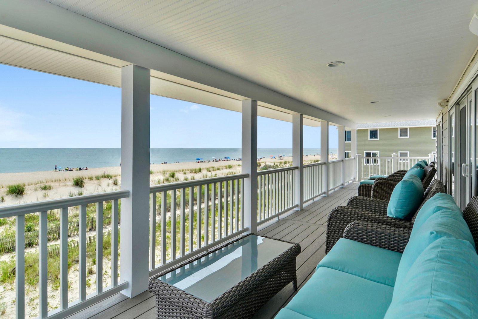 Enjoy your morning coffee with unobstructed ocean views from this covered veranda. Comfortable seating and the sound of waves create the perfect beachfront retreat.