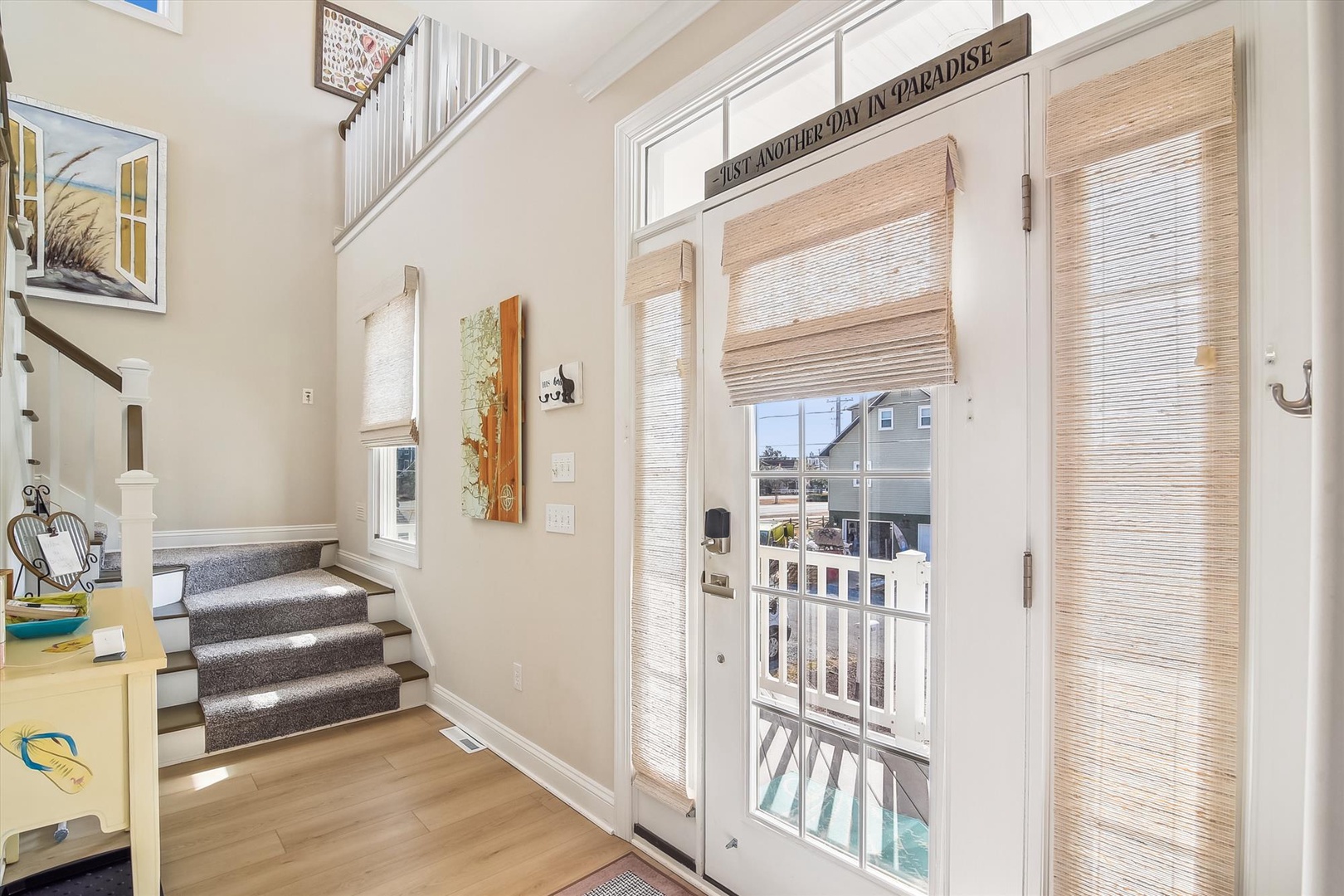 Bright and airy entryway welcomes you with high ceilings, warm wood floors, and charming coastal décor. French doors open to your private balcony overlooking the neighborhood.