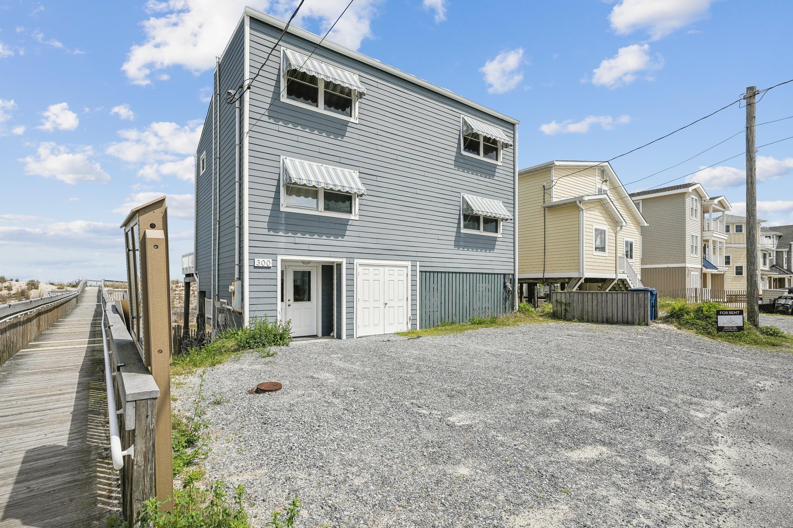 A modern beach house awaits in a quiet coastal neighborhood, with boardwalk access leading straight to the shore—your perfect seaside escape is just steps away.