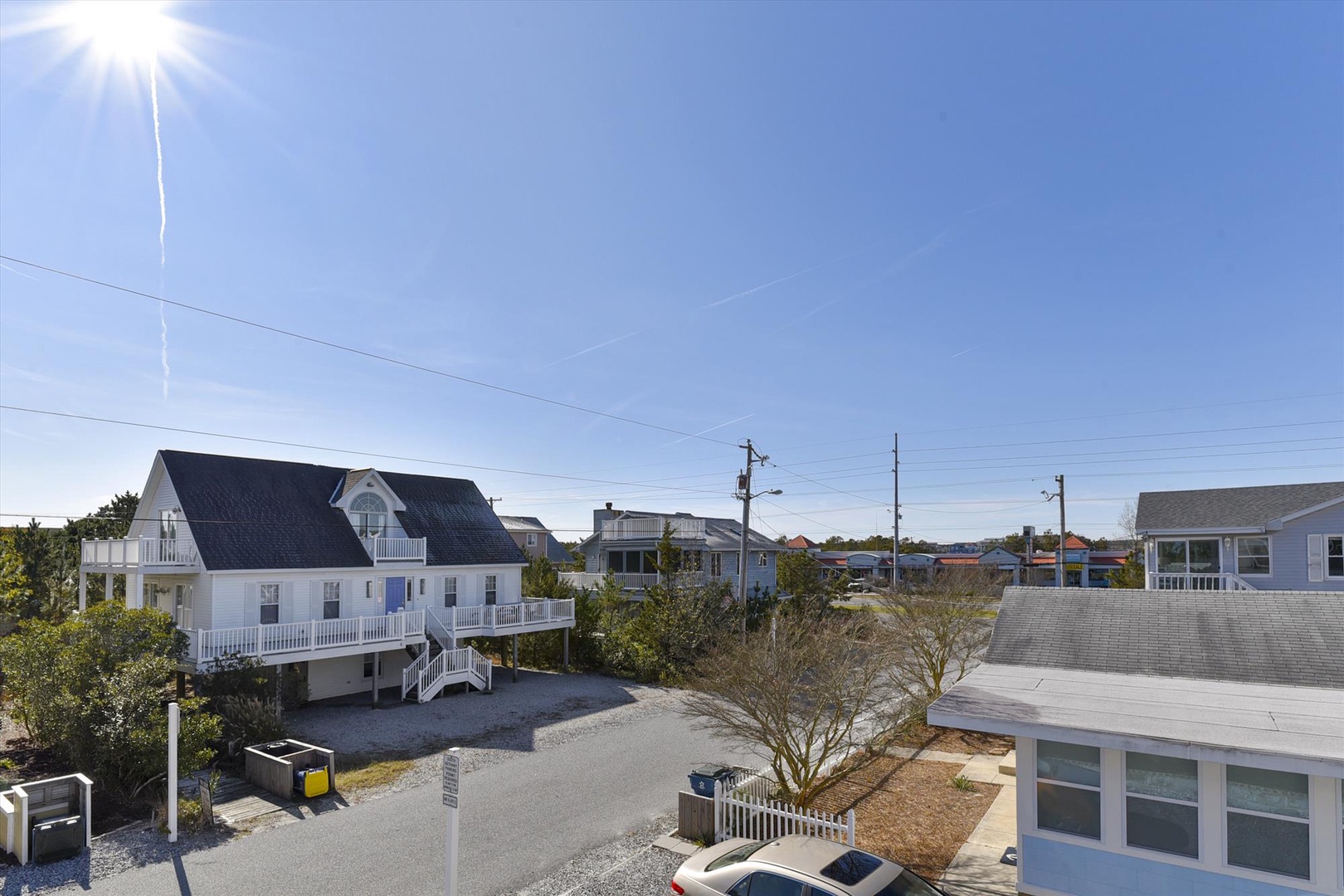 A peaceful coastal neighborhood with elevated beach homes, wide streets, and clear blue skies perfect for your seaside getaway.
