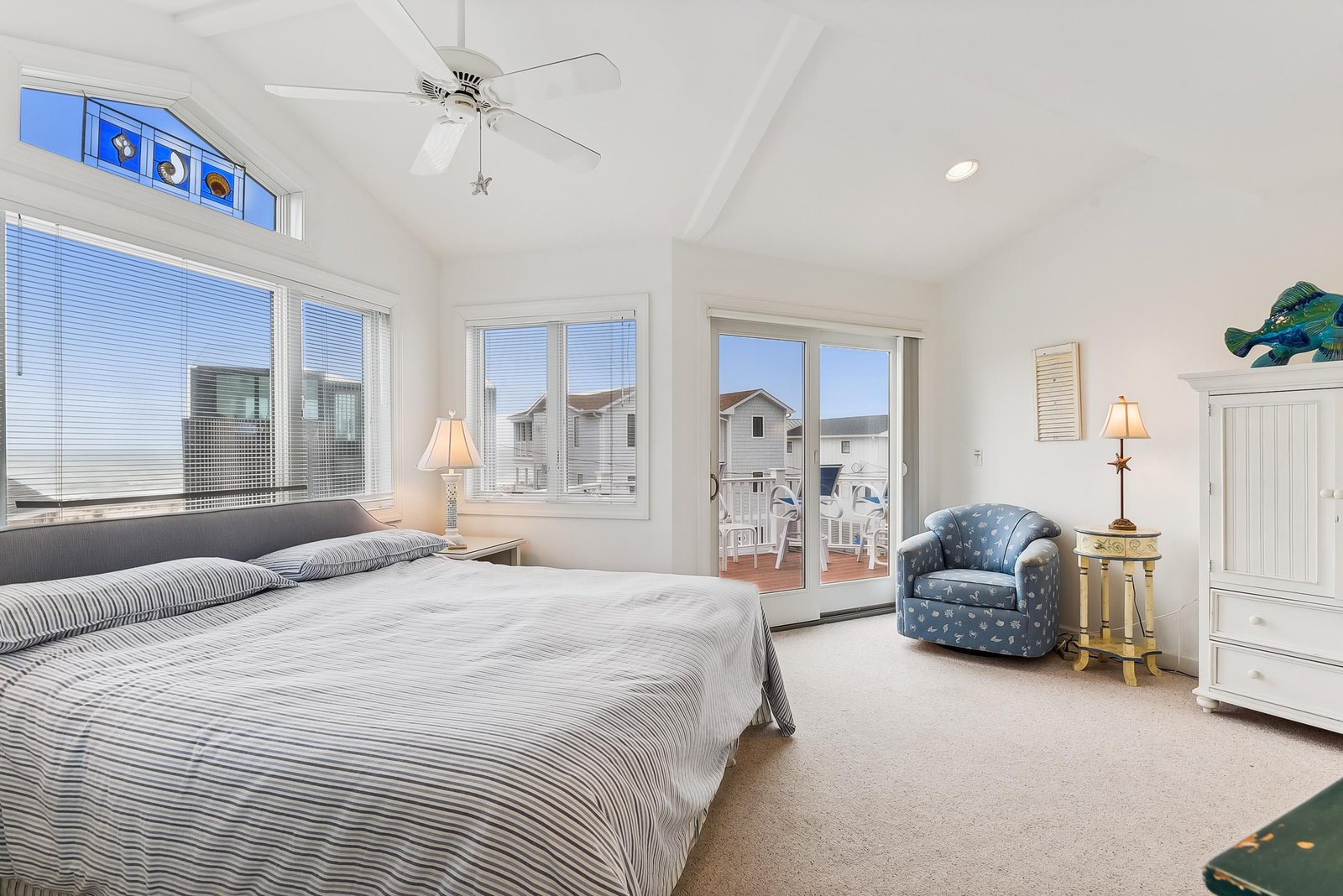Drift off in your bright, airy bedroom with vaulted ceilings and coastal charm. French doors open to your private balcony, while gentle sea breezes and natural light create a peaceful retreat.