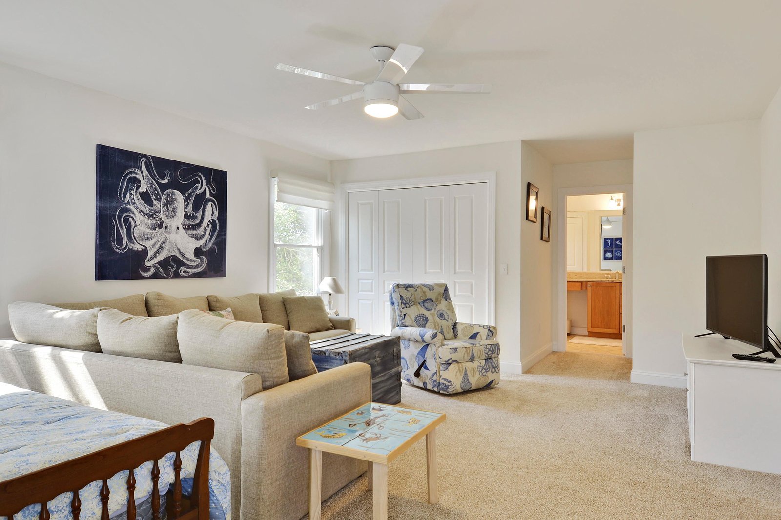 Sink into the plush sofa and feel the coastal breeze from the ceiling fan above. Your home away from home awaits, with a cheerful coastal vibe and room to relax after your beachside adventures.