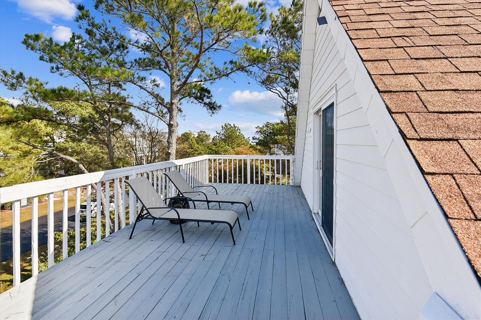 Unwind on your private deck with comfortable loungers overlooking lush treetops and peaceful surroundings.