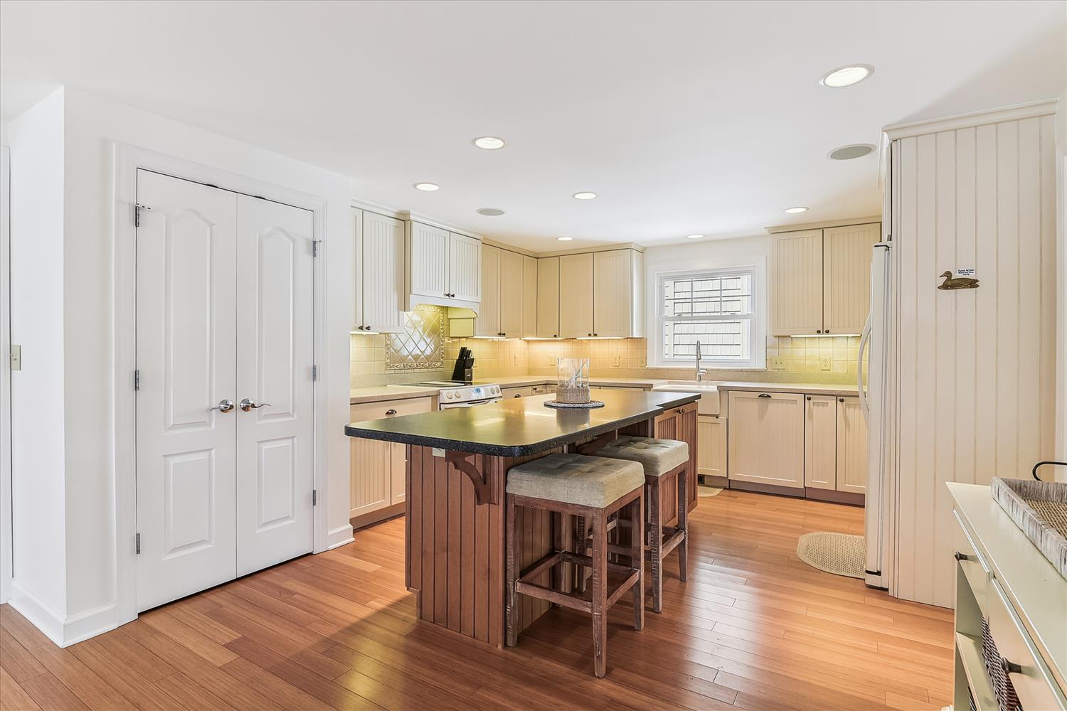 Your fully equipped kitchen features warm wood cabinetry, a spacious island with seating, and all the essentials for preparing your favorite meals in a welcoming space.