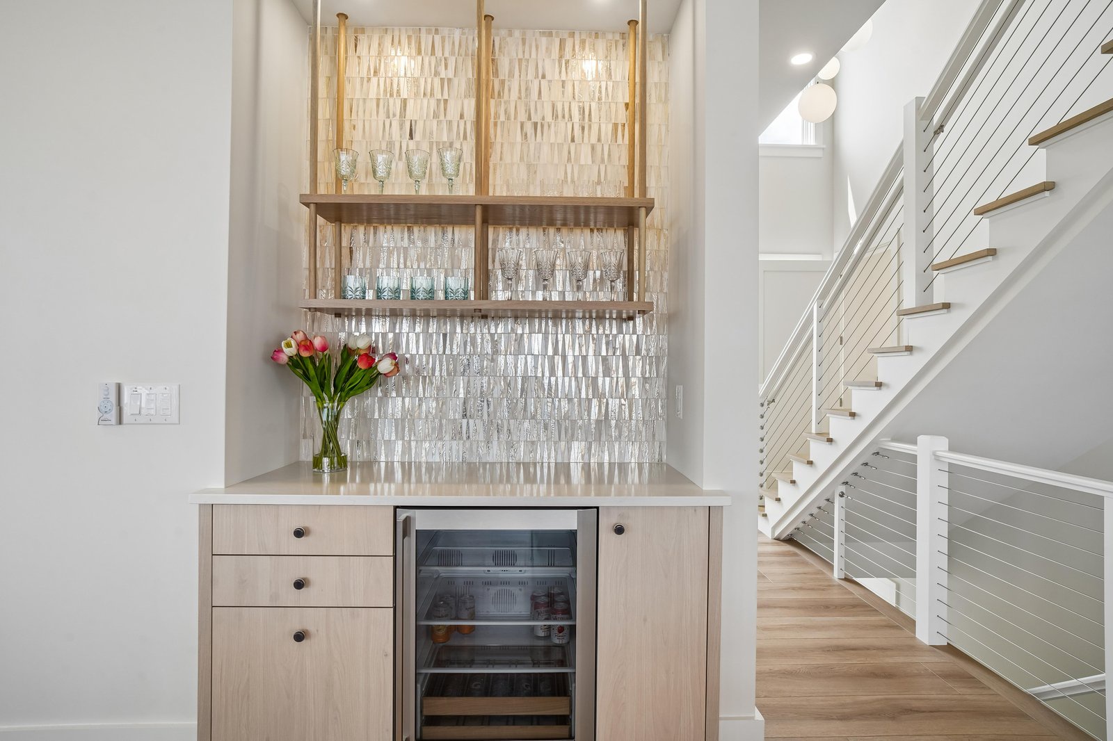 Your own stylish bar area awaits, complete with open shelving for your favorite glassware and a beverage cooler to keep drinks perfectly chilled.