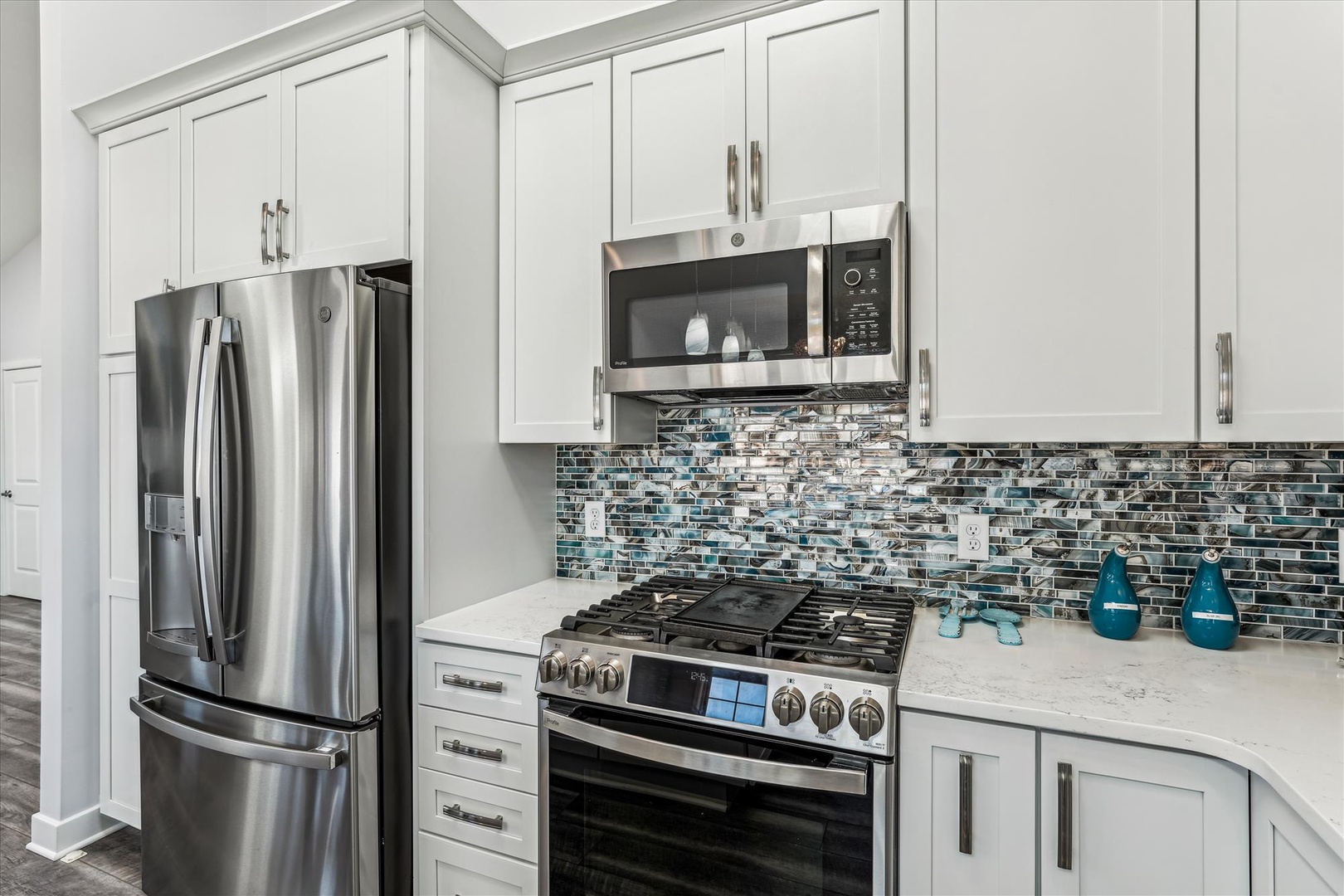 You'll love cooking in this bright kitchen with its stainless steel appliances, elegant backsplash, and spacious countertops—perfect for whipping up your favorite meals in style.