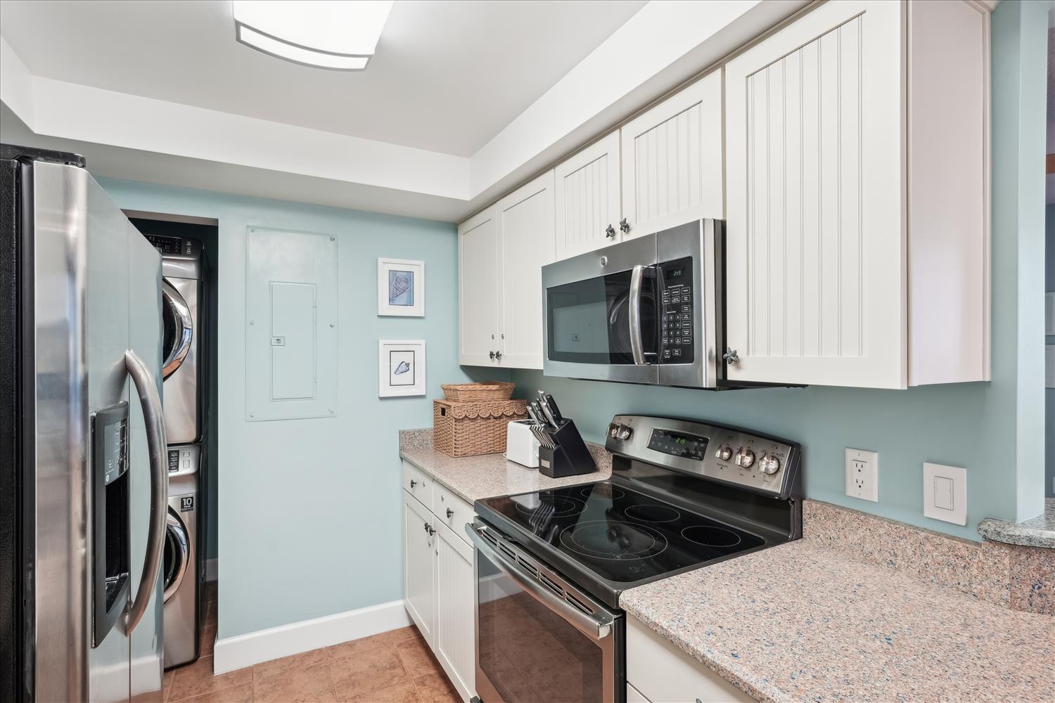 Your modern, fully-equipped kitchen features sleek stainless steel appliances, ample counter space, and a skylight that fills the room with natural light—perfect for preparing morning coffee or family meals.