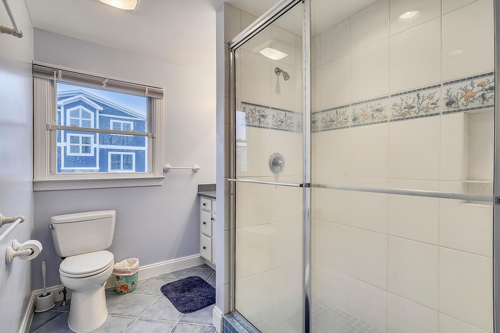 Fresh, clean bathroom with elegant tile accents and a spacious walk-in shower ready for your arrival.