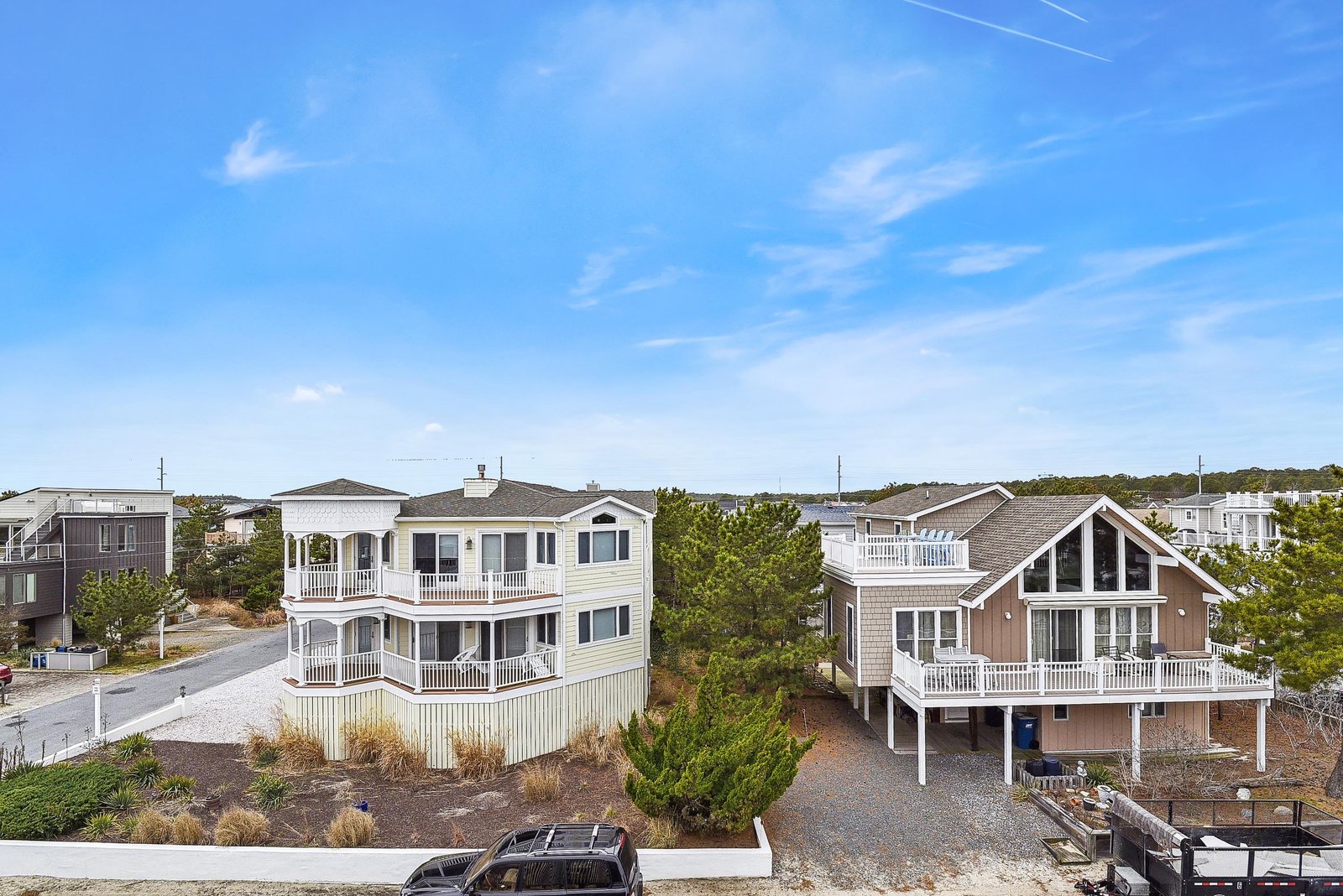 Coastal vacation homes nestled among natural dunes and greenery in a quiet beachside neighborhood, offering a peaceful retreat near the shore.