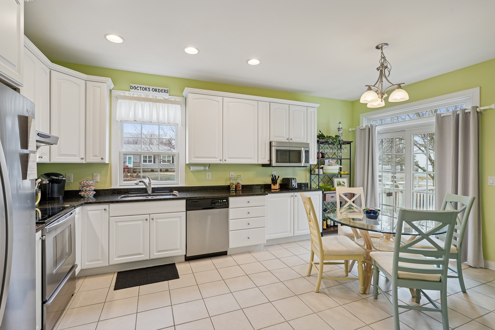 Your bright kitchen welcomes you with fresh green walls, white cabinets, and everything needed for memorable meals together.