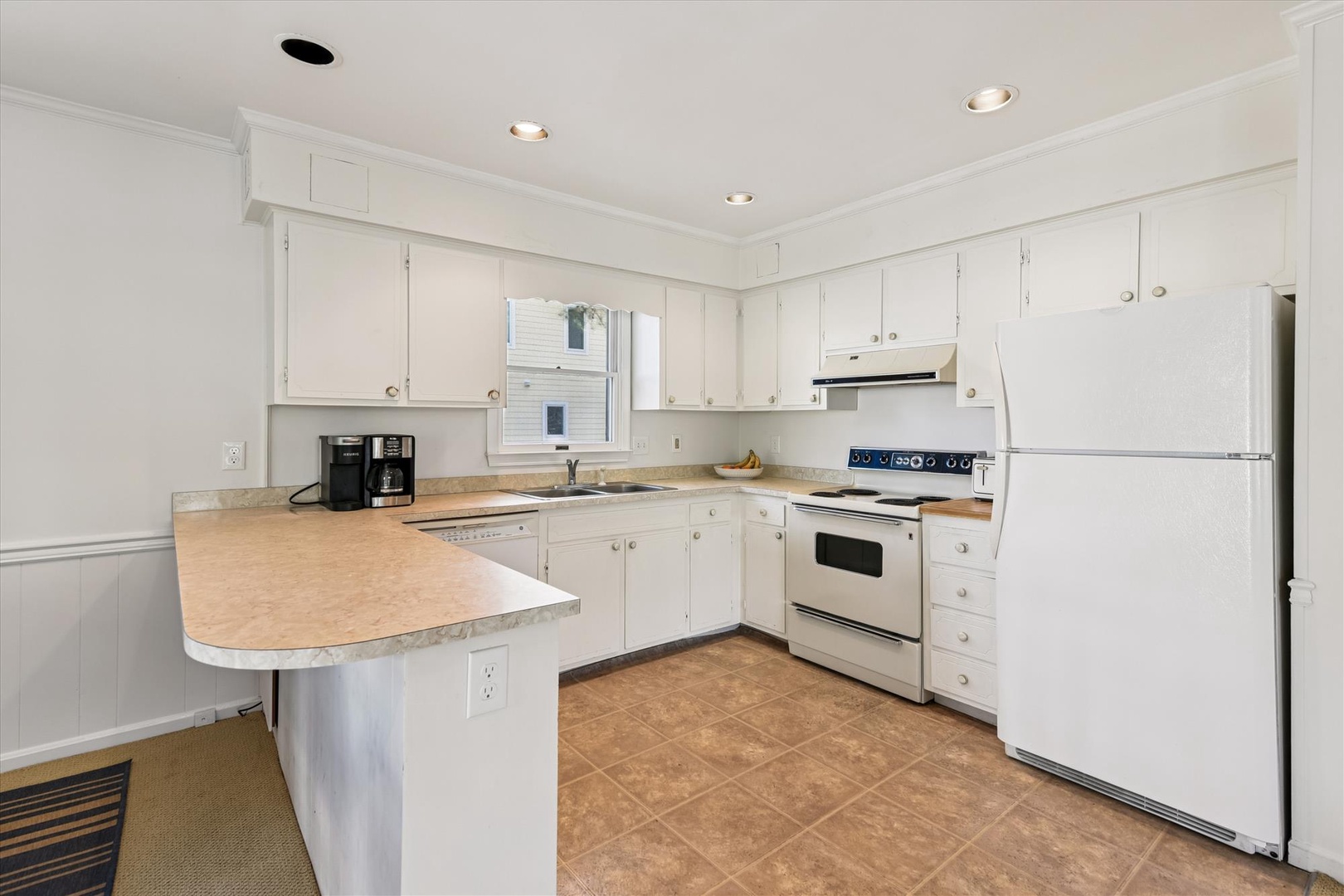 Your bright, fully-equipped kitchen awaits with crisp white cabinets, ample counter space, and modern appliances for preparing memorable meals.