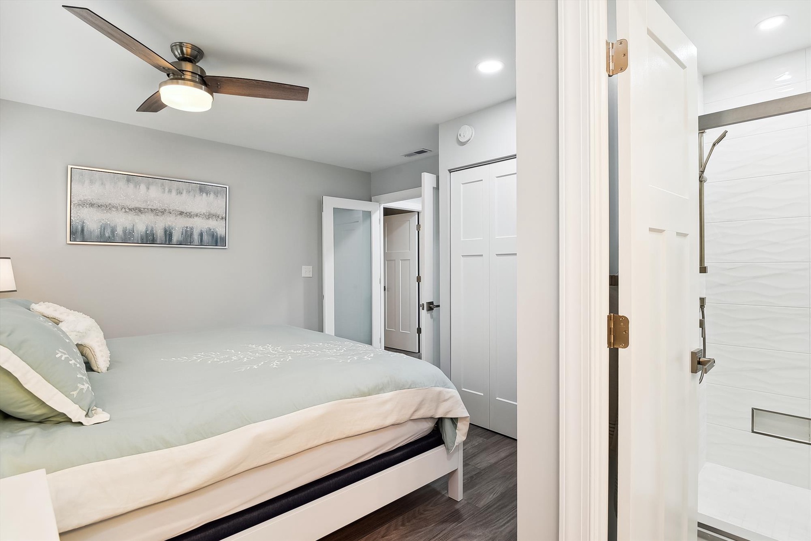 Unwind in your serene bedroom with plush linens, a whisper-quiet ceiling fan, and a sleek en-suite bathroom just steps away.
