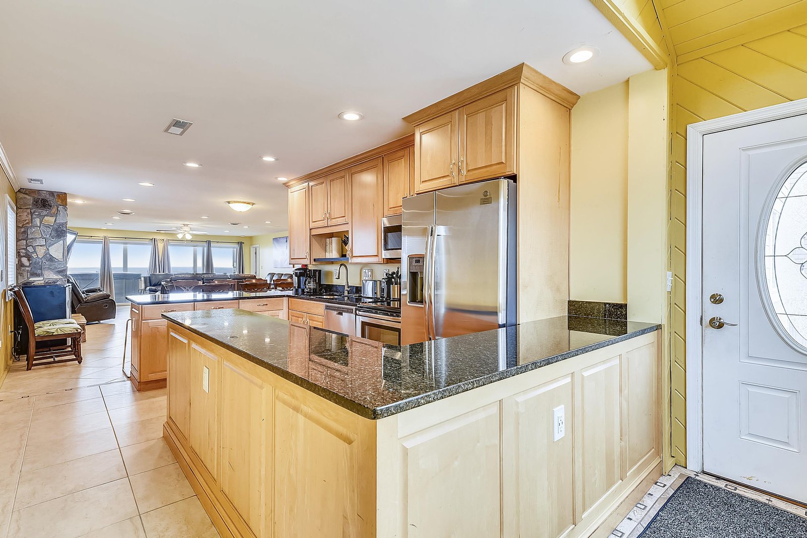 Imagine preparing your favorite meals in this spacious kitchen with gleaming granite countertops and stainless steel appliances, all while soaking in the stunning ocean view beyond.