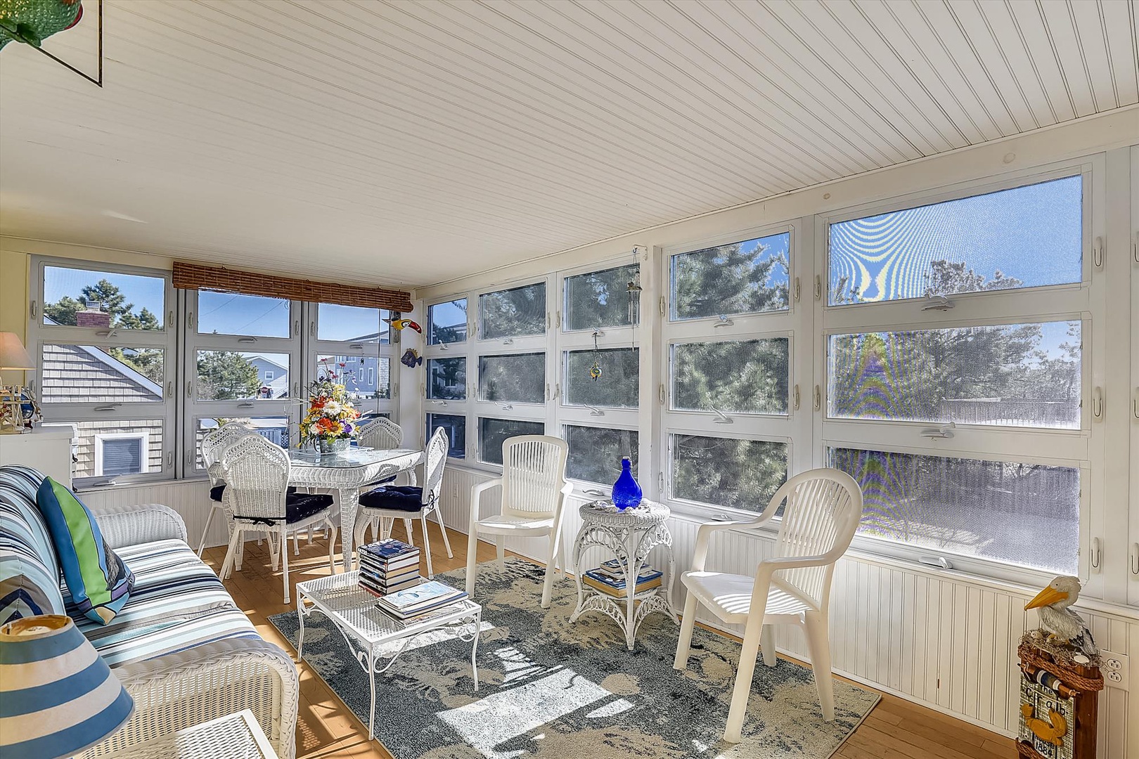 Settle into your bright sunroom with wicker seating and sweeping windows, where you'll enjoy morning coffee while gazing at the neighborhood views and feeling coastal breezes.