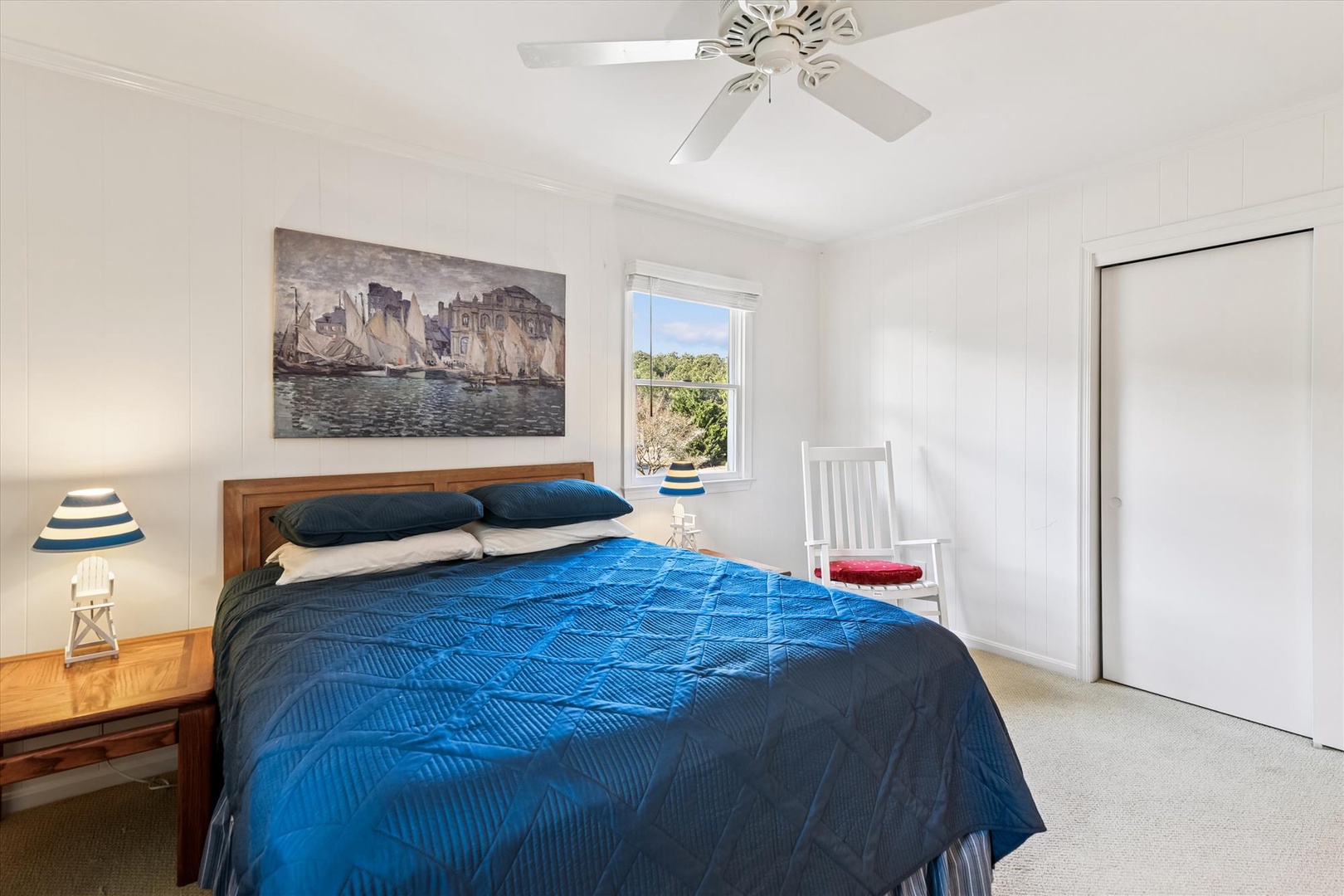 Rest peacefully in your bright bedroom with coastal charm, featuring a comfortable queen bed and leafy garden views from your window.