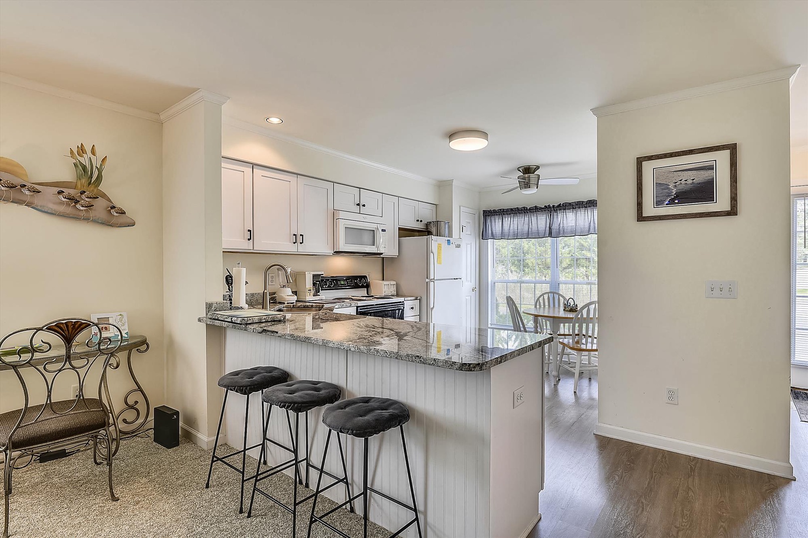 You'll love gathering around this bright, open kitchen featuring granite countertops, breakfast bar seating, and a cozy dining nook with views of the outdoors.