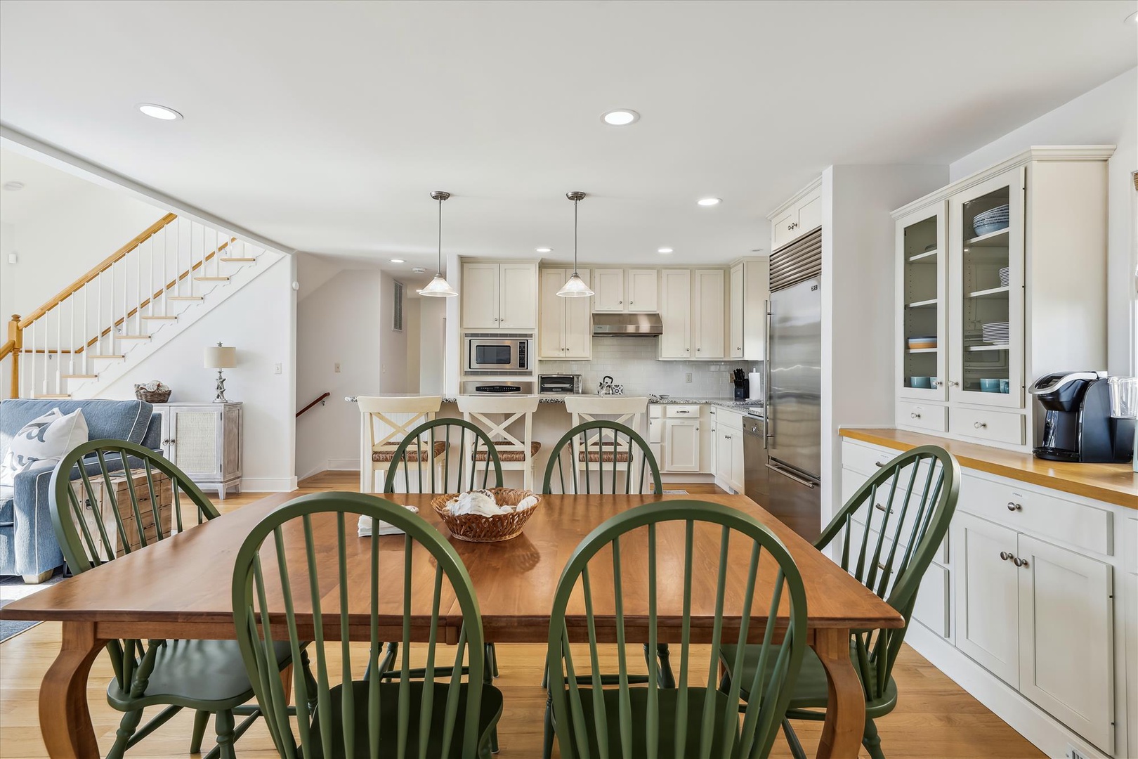 Gather around this inviting dining table in your open-concept space, where the fully-equipped kitchen makes meal prep a breeze and everyone can stay connected.