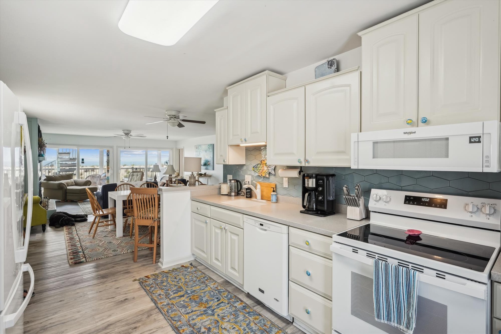Your vacation starts in this bright, open-concept space where the fully equipped kitchen flows into a cozy living area with stunning water views just beyond the windows.
