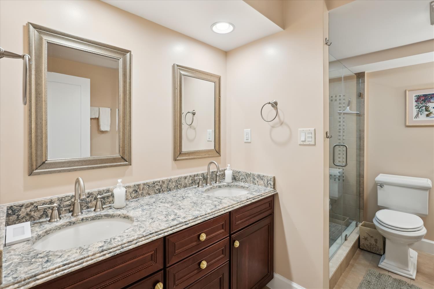 Freshly updated bathroom with dual vanities, gleaming granite counters, and a glass-enclosed shower waiting for you to unwind after exploring.