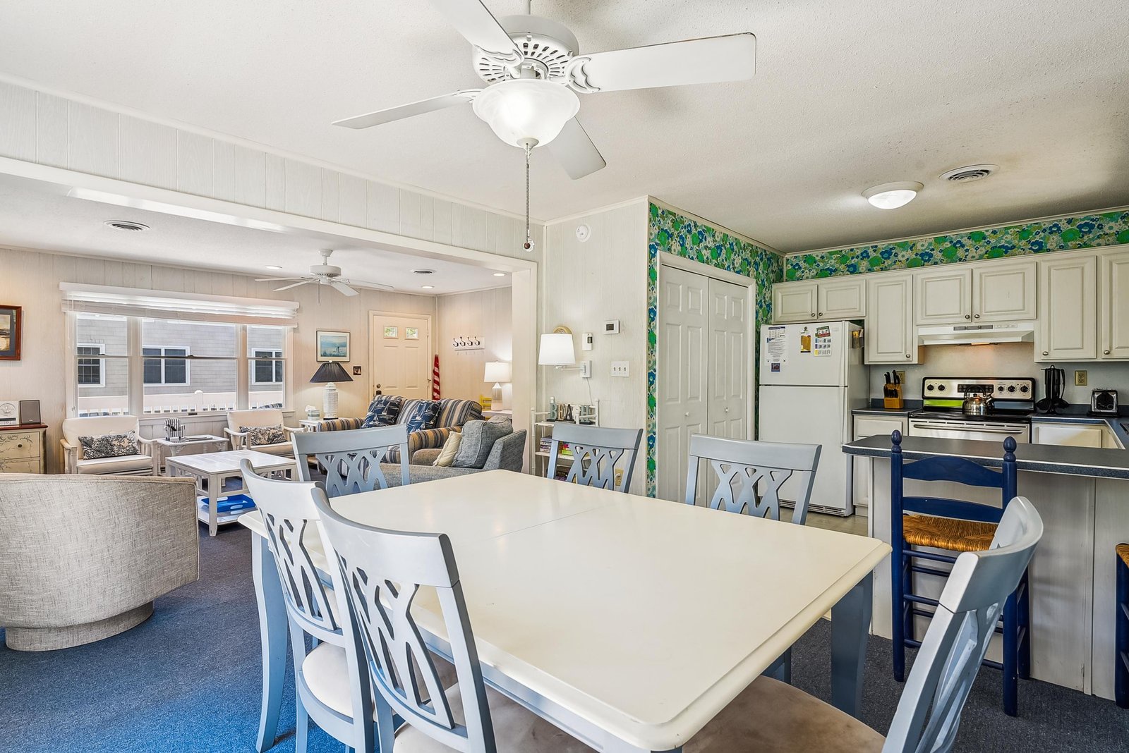 Gather around the spacious dining table where meals and memories come together, with your fully equipped kitchen and comfortable living area just steps away, all bathed in soft natural light.