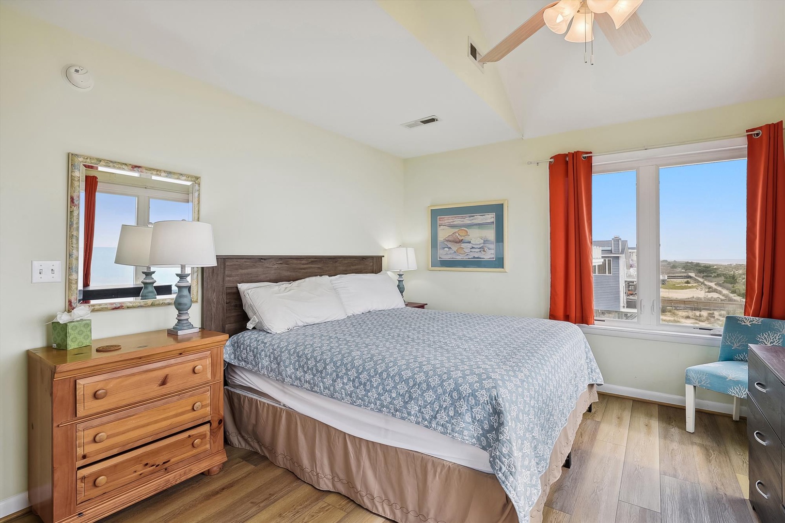 Wake up to breathtaking coastal views through the large windows framing this peaceful bedroom. Soft bedding invites relaxation, while the bright, airy space and warm wood accents create your perfect beachside retreat.