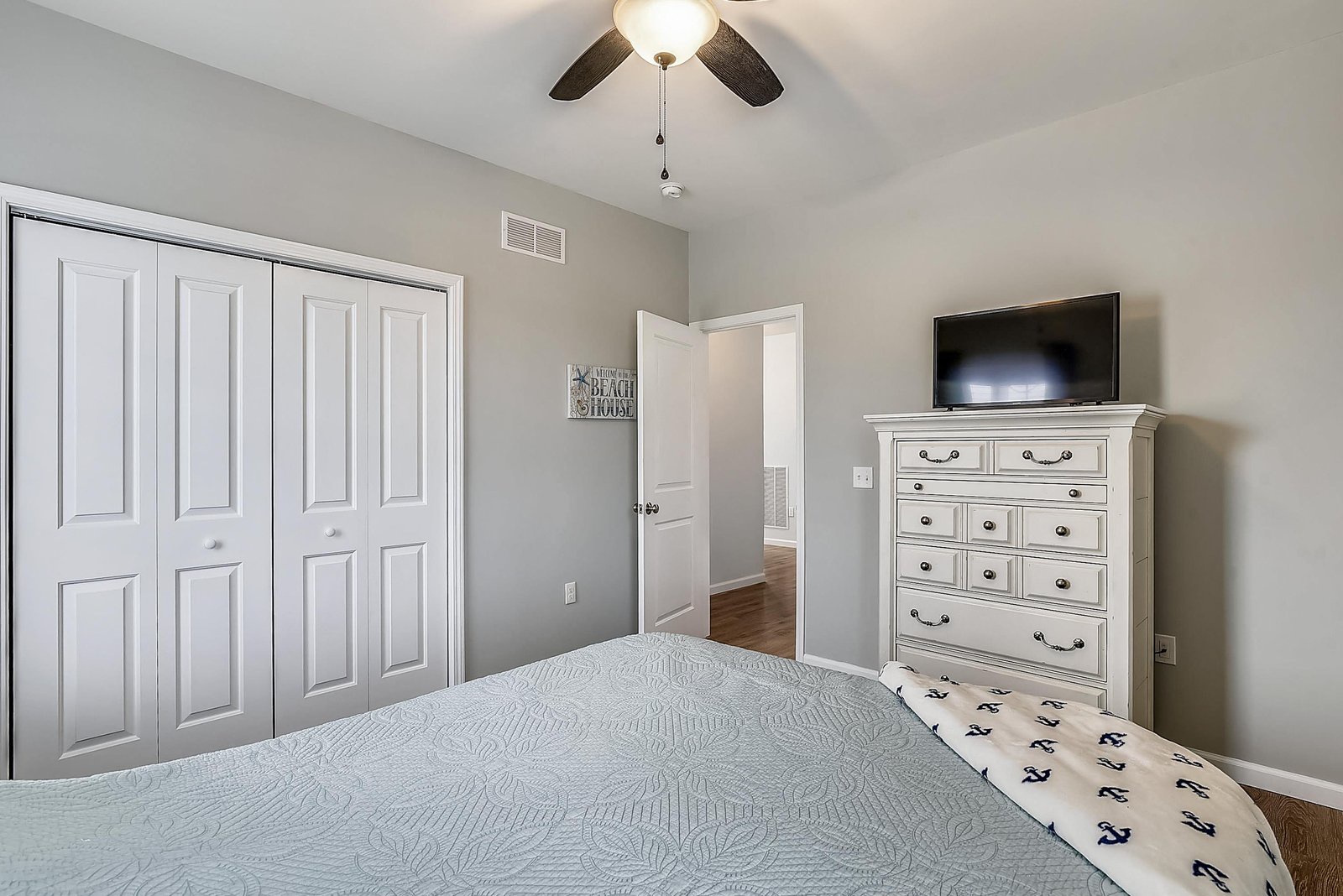 Rest easy in your airy bedroom, outfitted with a plush bed, ample storage, and gentle ceiling fan overhead.