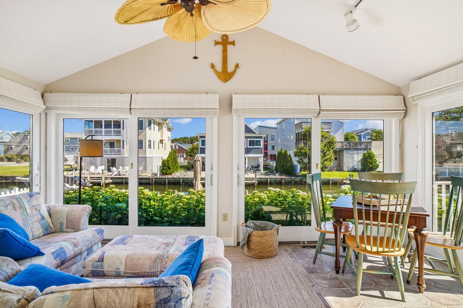 Imagine relaxing in this sunlit space where nautical charm meets waterfront views. Your cozy seating invites quiet moments, while the dining area and vaulted ceilings create an airy, welcoming retreat.
