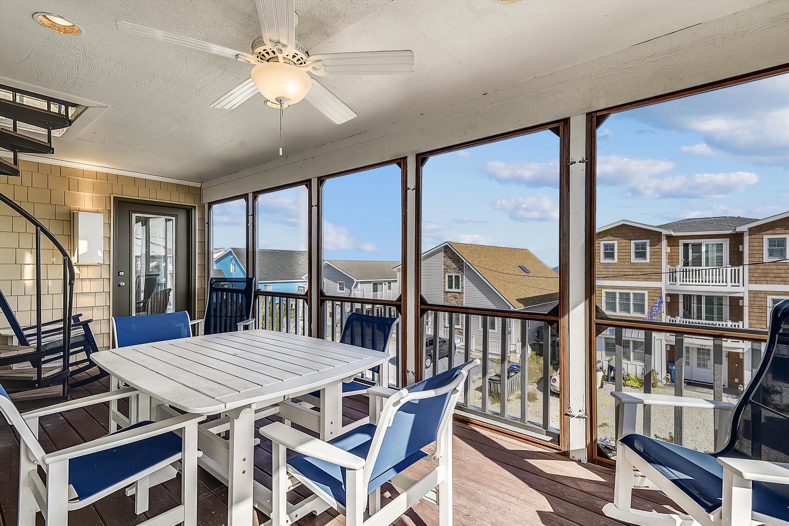 Gather around the sunny dining area with coastal breezes, ceiling fan, and relaxed seating for memorable meals together.