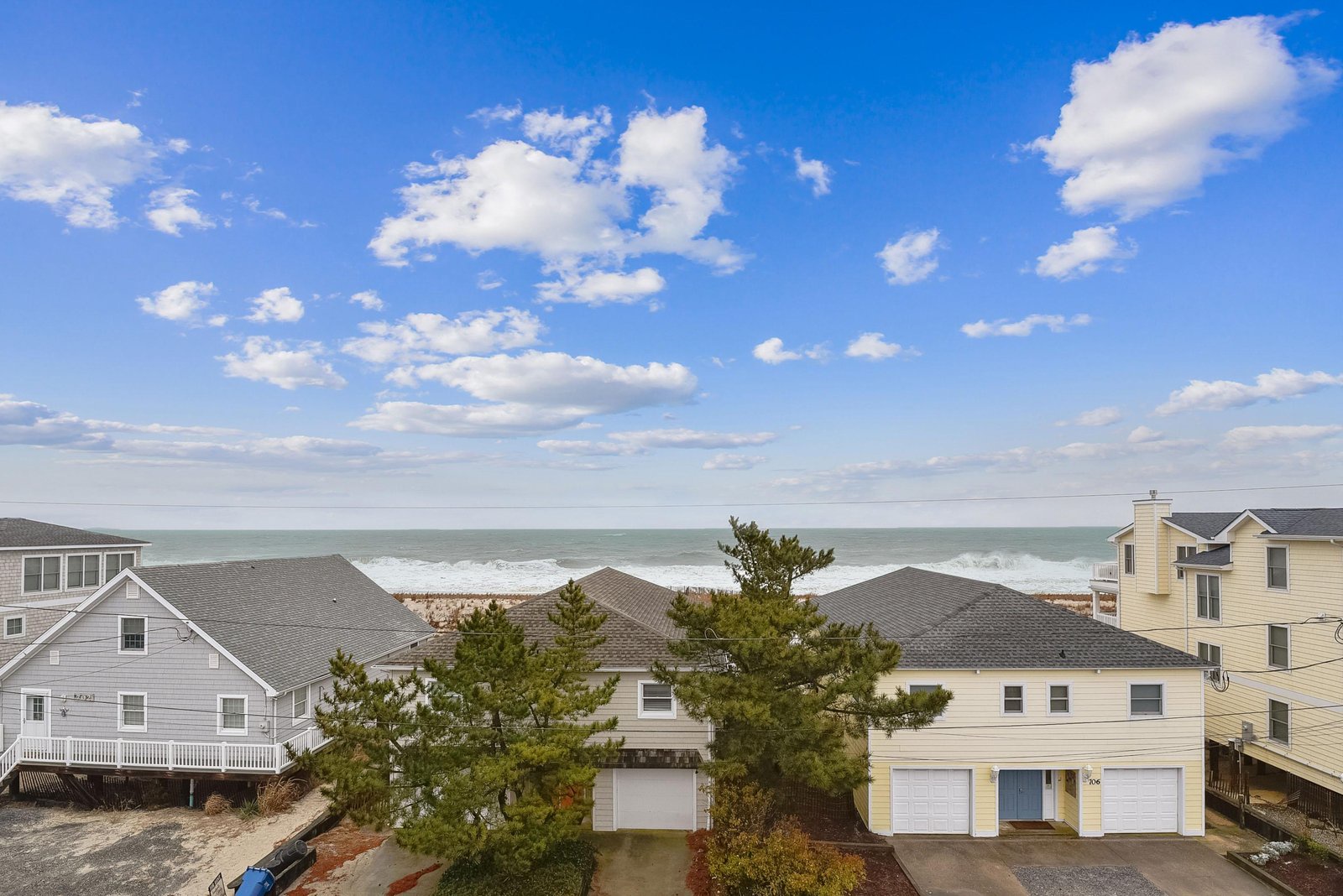 Beachfront neighborhood with direct ocean access and homes just steps from the sand, offering a serene coastal setting under wide-open skies.