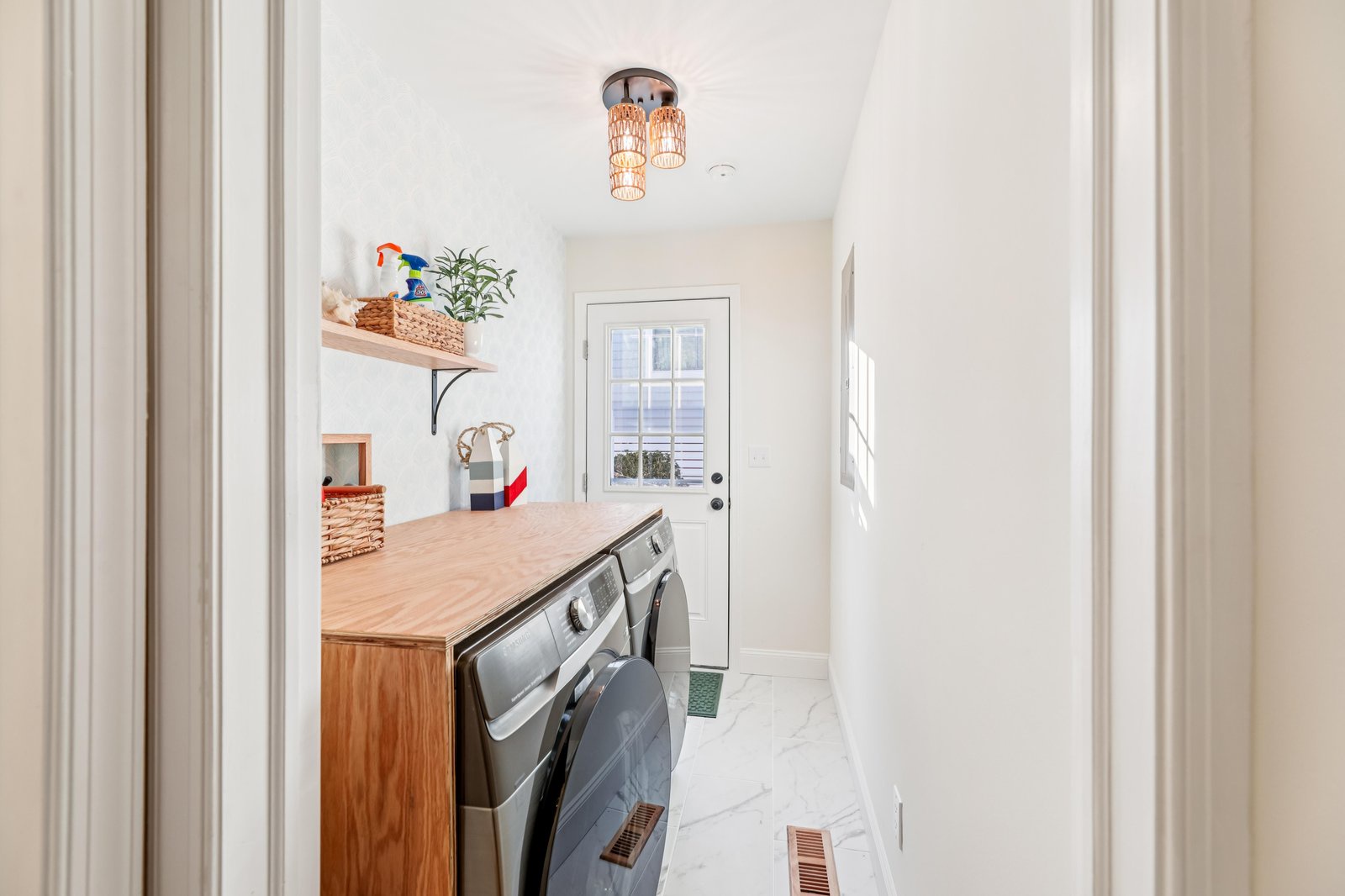 A bright, cheerful laundry room awaits, with gleaming countertop workspace and natural light streaming through. You'll appreciate the thoughtful design and convenient access to the outdoors.