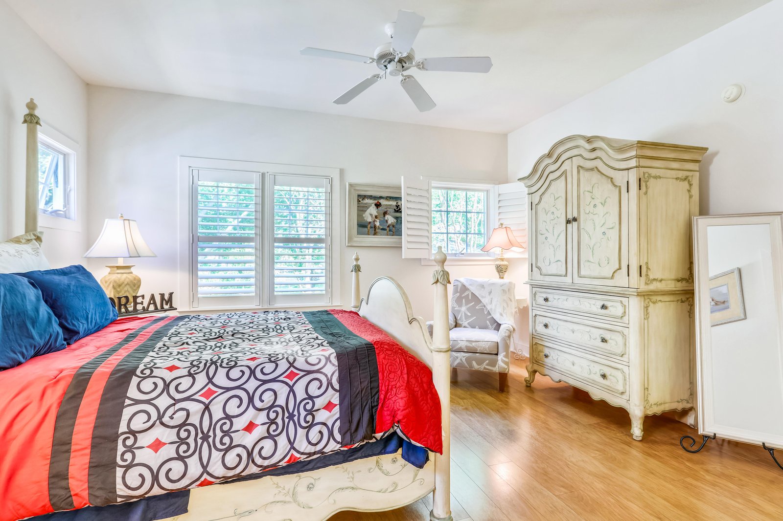Settle into this beautifully appointed bedroom, where you'll find charming vintage-style furnishings and a cozy reading nook bathed in natural light from plantation shutters.