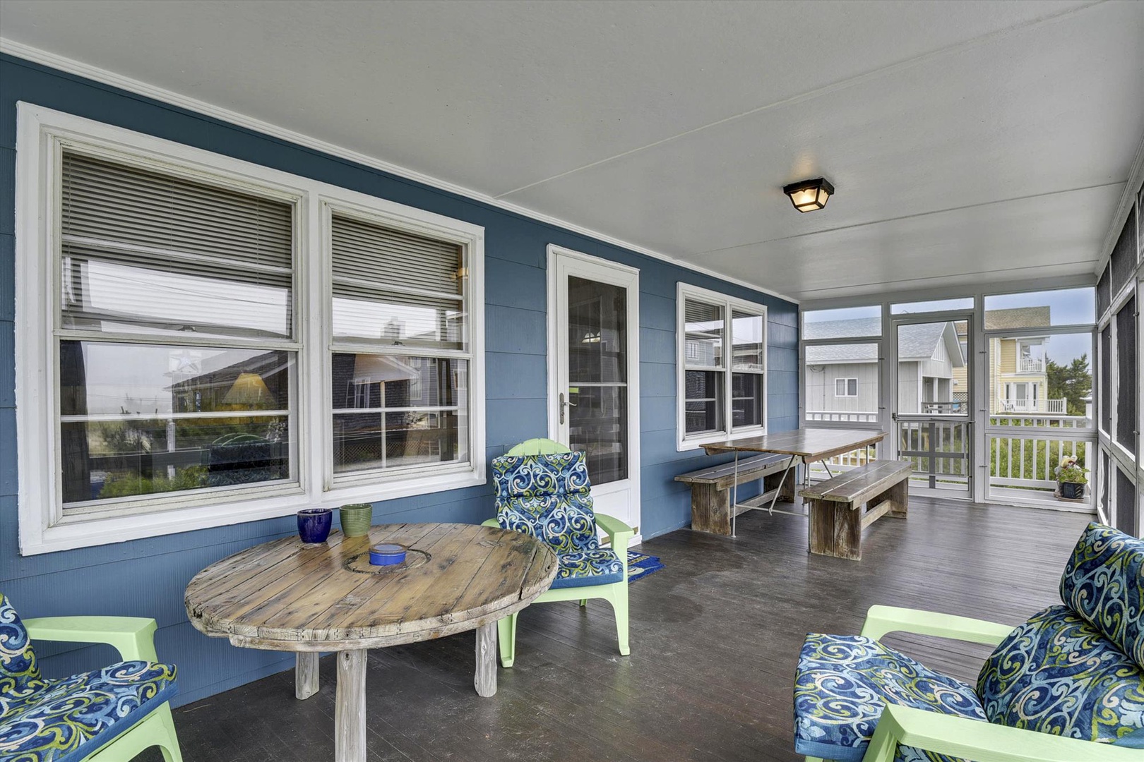 Gather with family and friends on your covered porch, complete with cozy seating and a rustic dining table perfect for alfresco meals or morning coffee in the sea breeze.