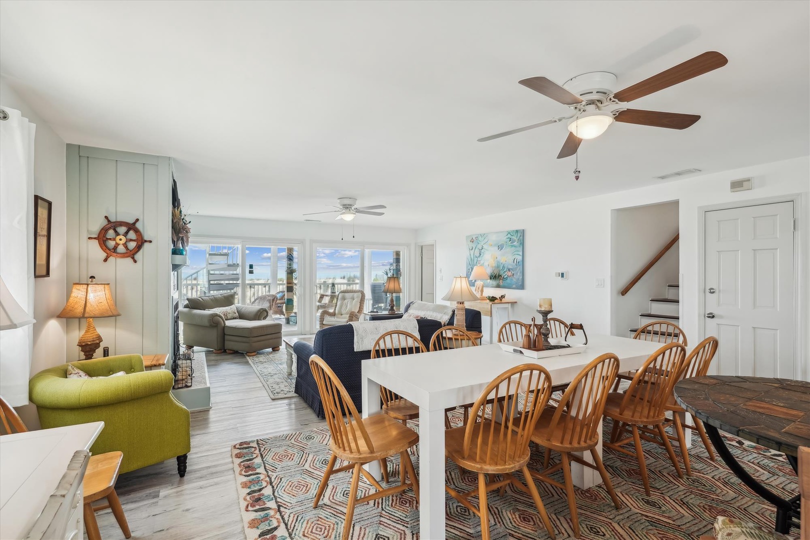 Step into this bright, airy living space where nautical charm meets coastal comfort. Large windows frame stunning beach views while ceiling fans keep you cool.