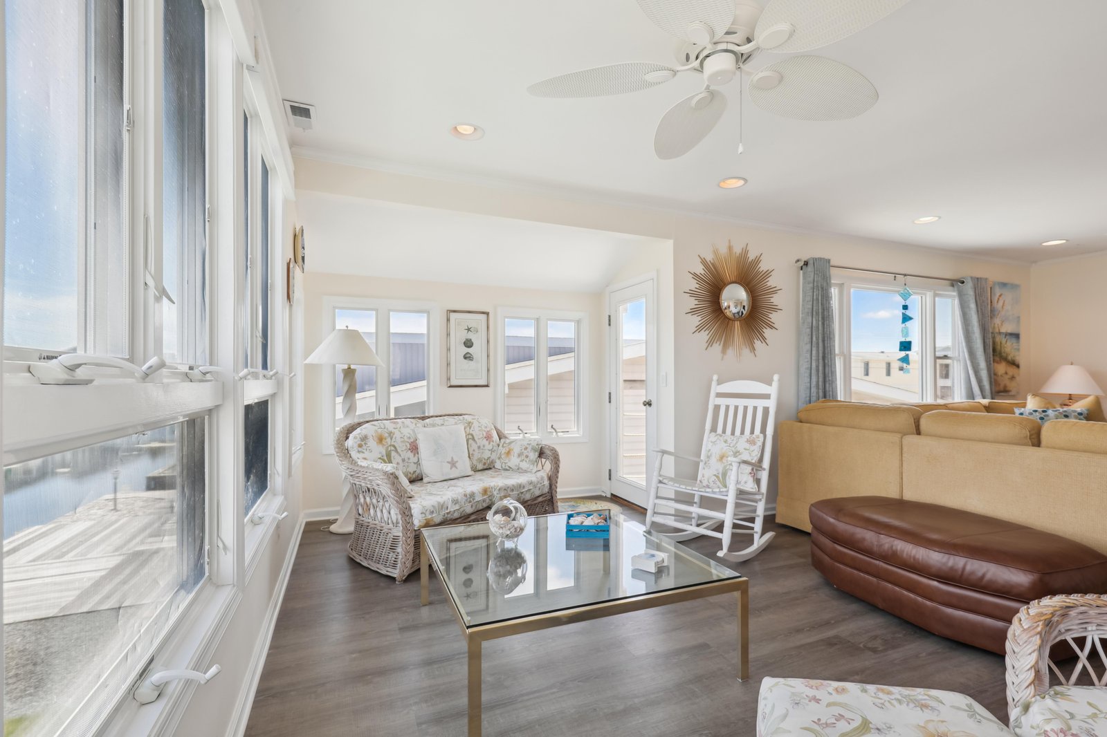 Settle into your bright coastal retreat, where soft natural light pours through windows and ocean breezes keep you cool. Unwind with a good book in the rocking chair or gather with loved ones around the glass coffee table after a perfect beach day.