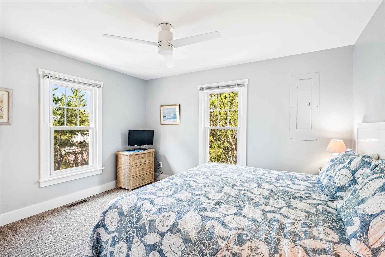 Wake up refreshed in your serene bedroom with ocean-themed linens, natural light streaming through dual windows, and peaceful garden views.