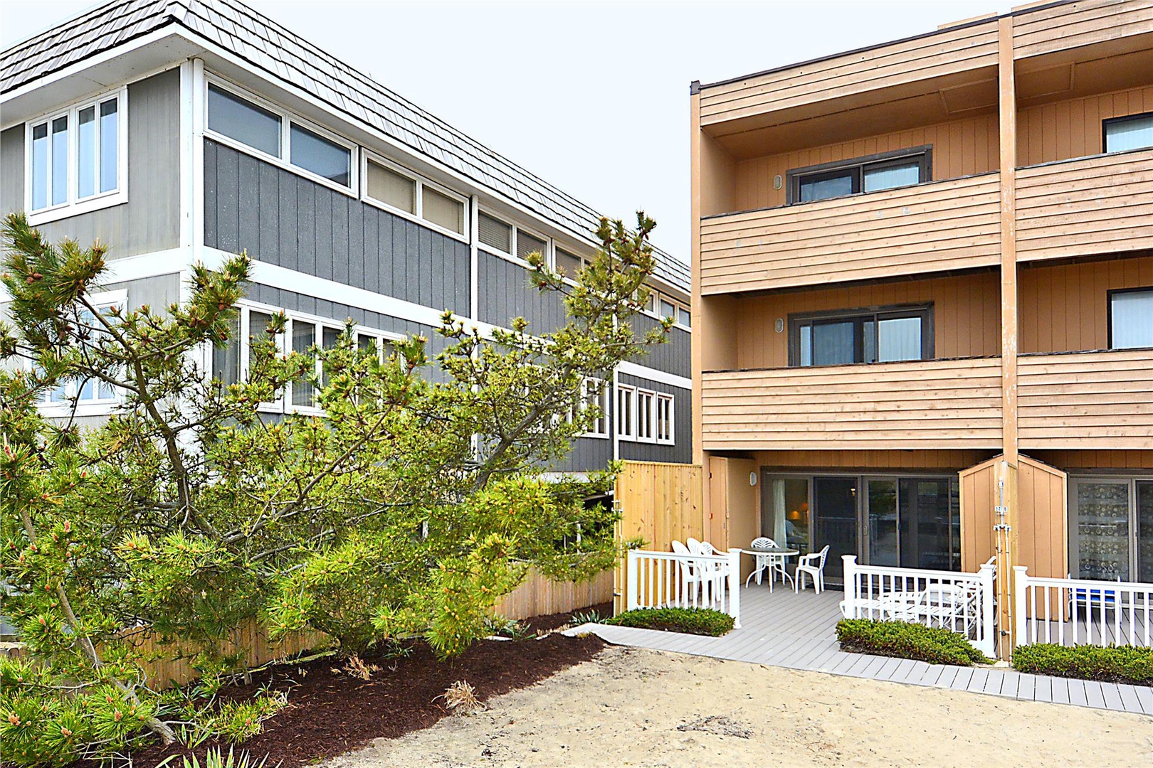 Contemporary vacation buildings with private patios and lush landscaping create a relaxing coastal retreat setting.