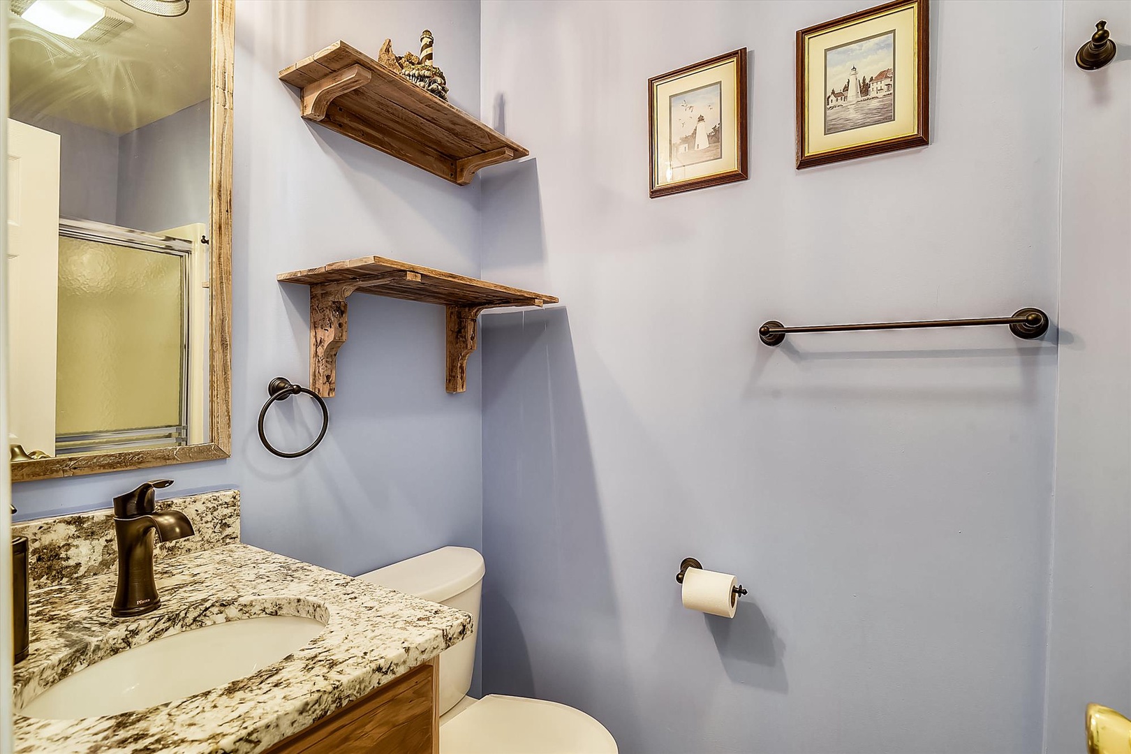 You'll appreciate the charming bathroom with its rustic wood shelves, granite vanity, and elegant bronze fixtures creating a cozy, thoughtfully designed space.