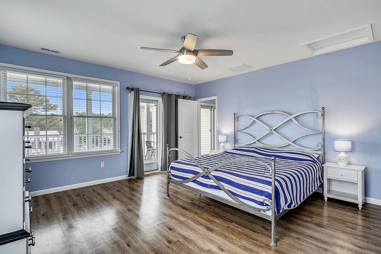 Slip into restful nights in your bright coastal bedroom, where the gentle ceiling fan and private balcony access promise refreshing breezes and serene mornings.