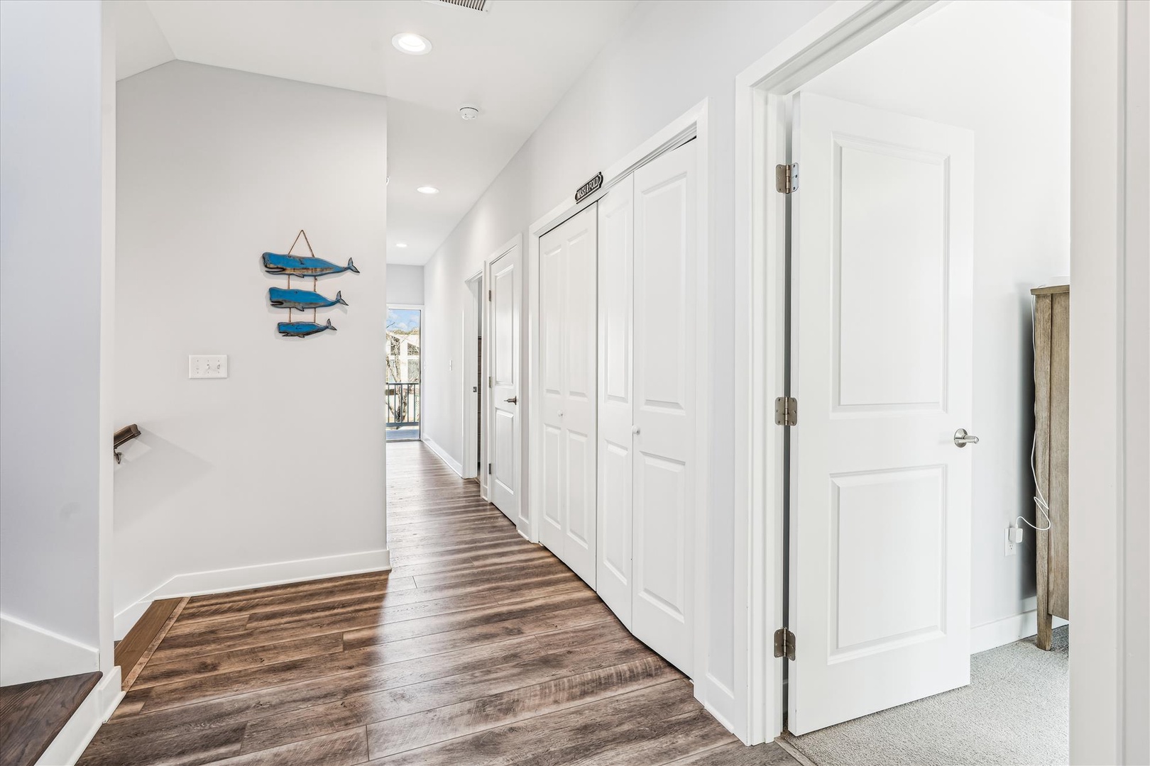 Walk through your spacious hallway with rich hardwood floors, crisp white walls, and charming coastal touches that welcome you home.