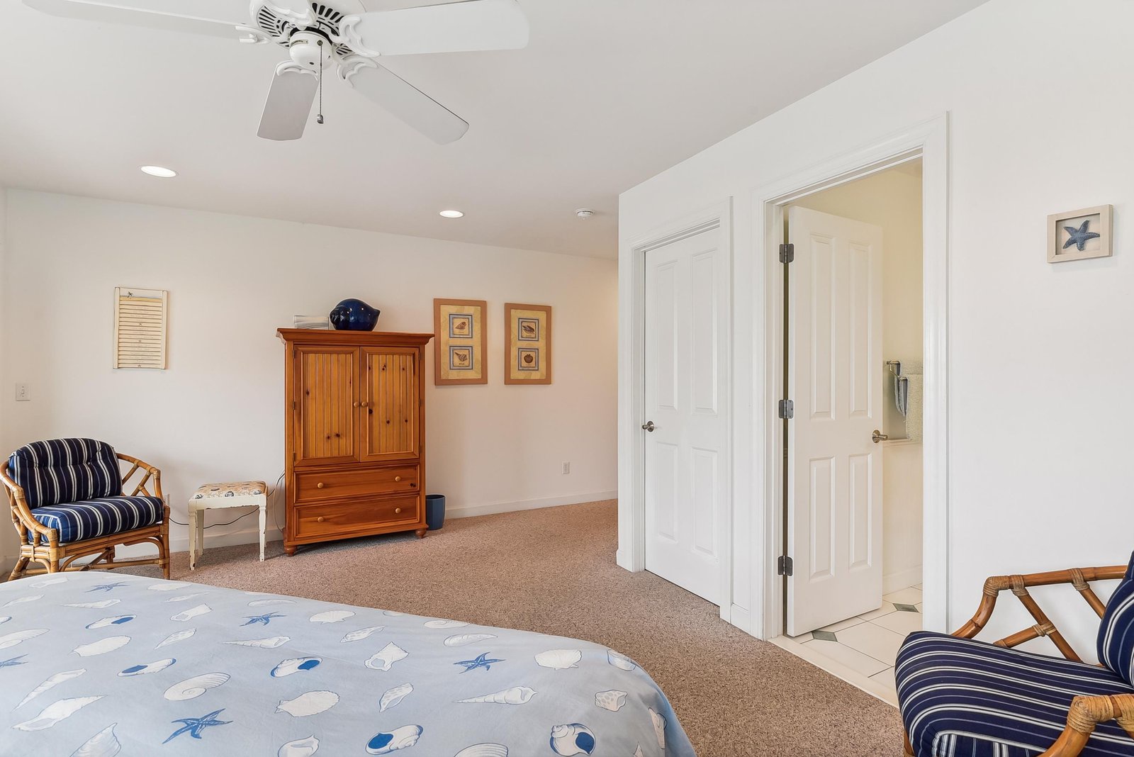Bright bedroom with coastal charm and your own ceiling fan for comfort. Relax in cozy seating or settle into a peaceful night's sleep.