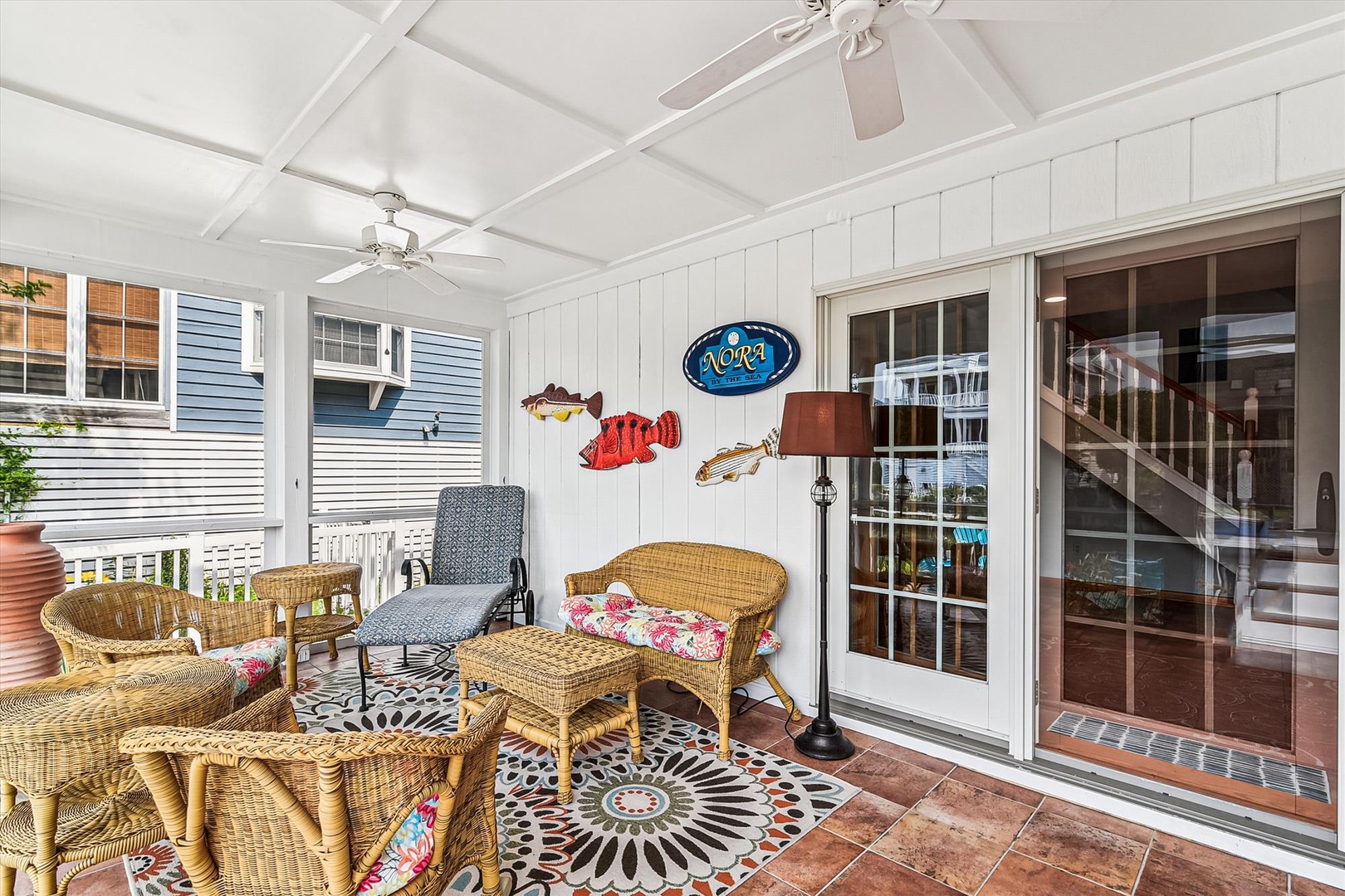 Step out to your covered patio and settle into the wicker seating, where tropical fish art and cool tile floors set the tone for laid-back coastal evenings by the breeze.