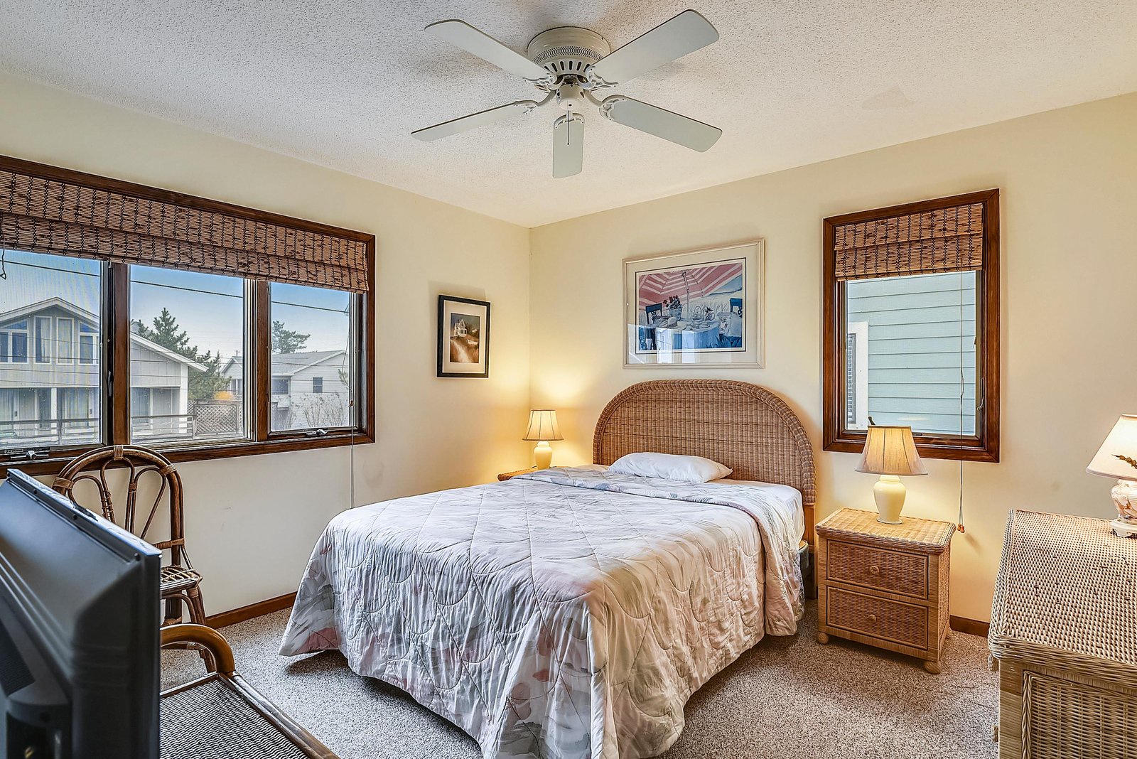 Relax in your coastal-inspired bedroom with a cozy queen bed and natural wicker touches. Two windows fill the room with soft light, while the ceiling fan keeps things comfortable year-round.