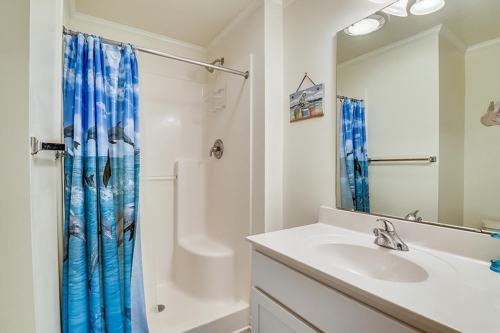 You'll find a bright, clean bathroom with a spacious tub-shower combo and coastal-themed accents. Fresh towels and beach-inspired decor create a calming retreat after a day of adventure.