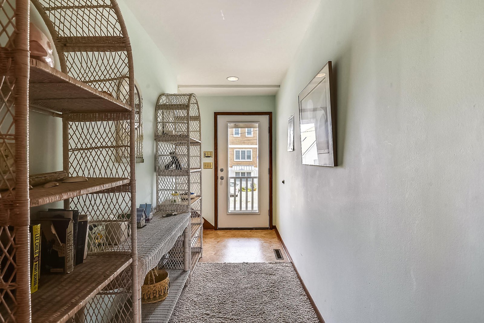 Step into a bright, welcoming entryway with charming wicker storage and warm wood floors that set the tone for your coastal retreat.